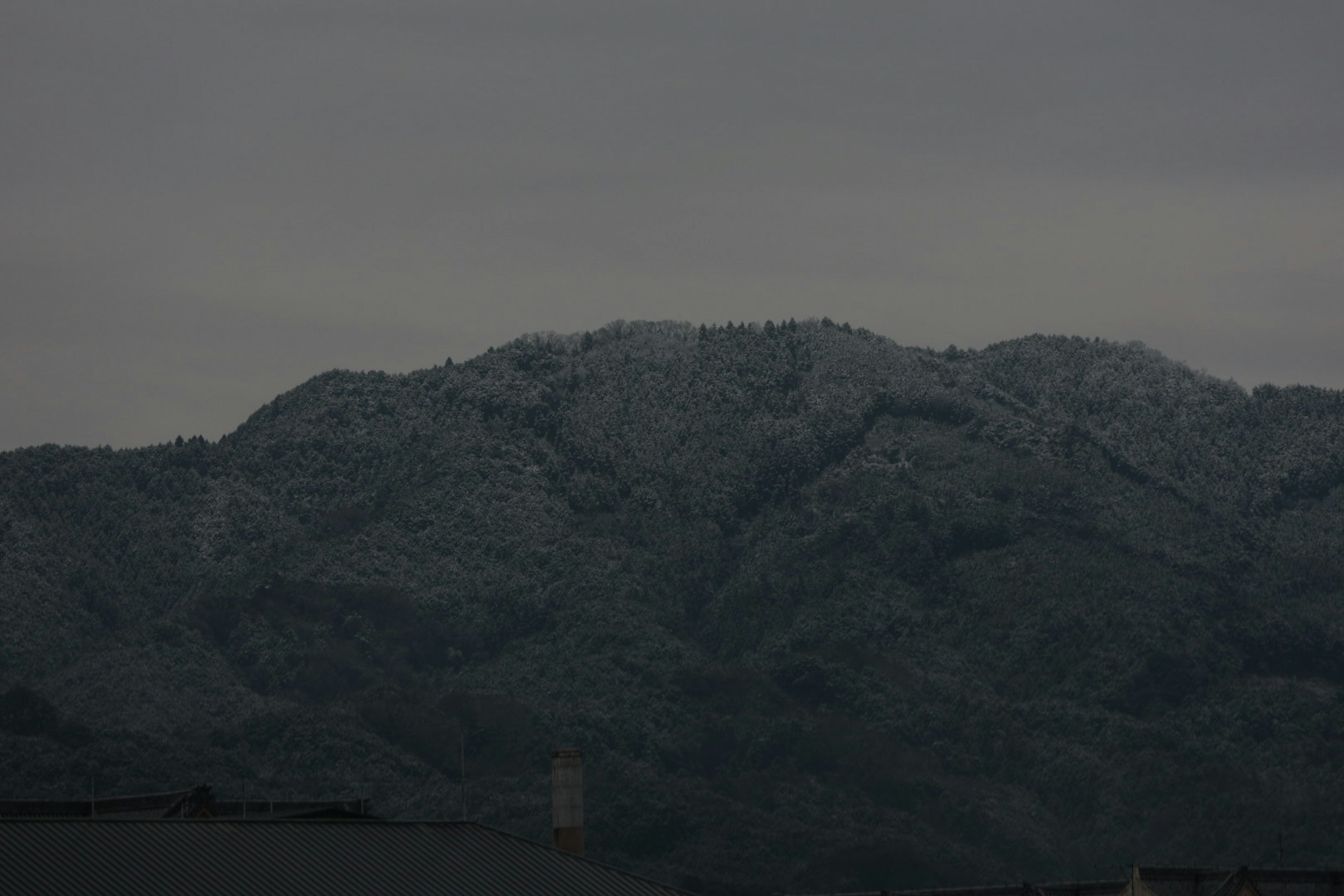 雪覆盖的山脉在阴暗的天空下