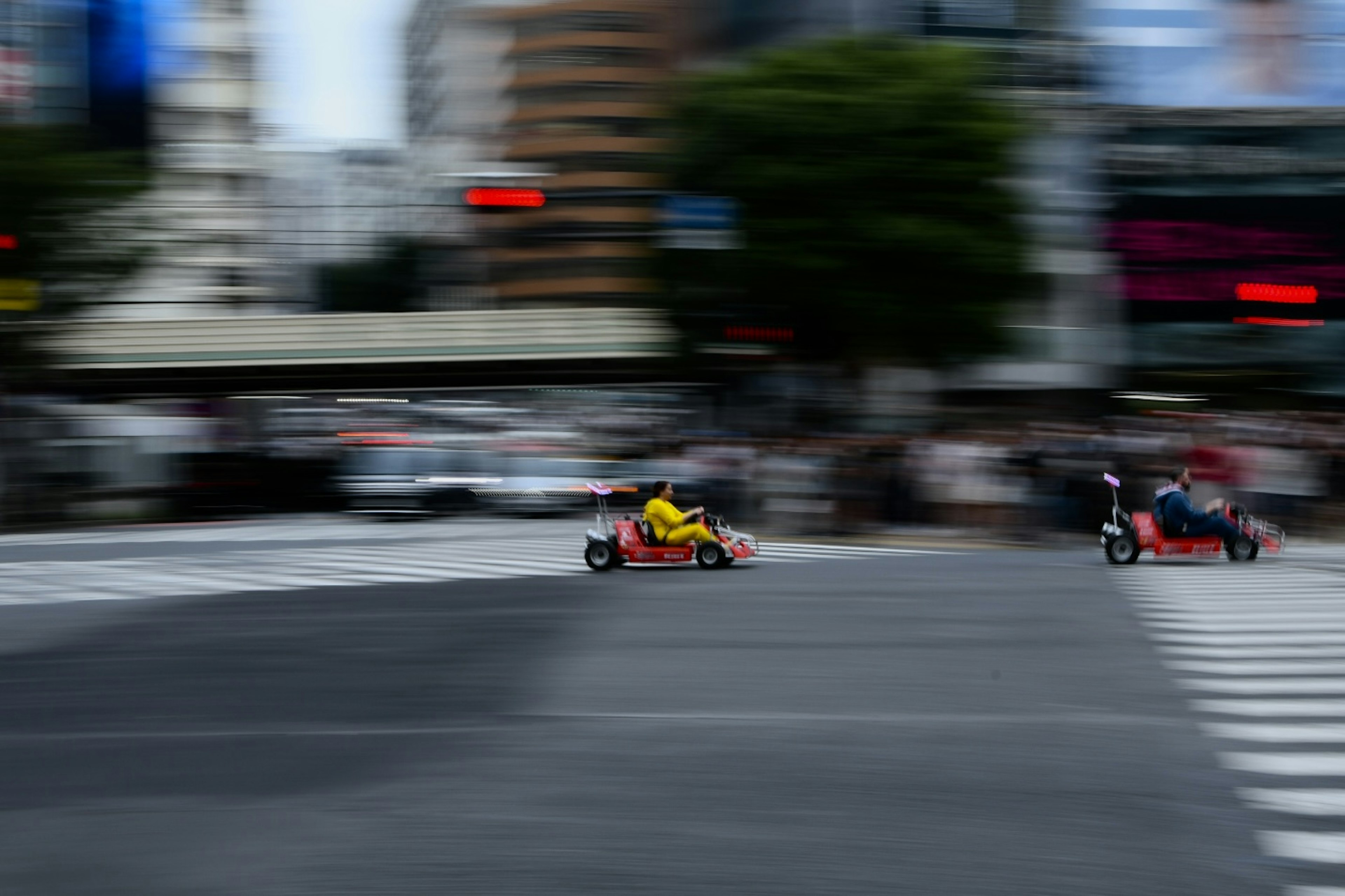 Karts compitiendo en una intersección concurrida en Tokio