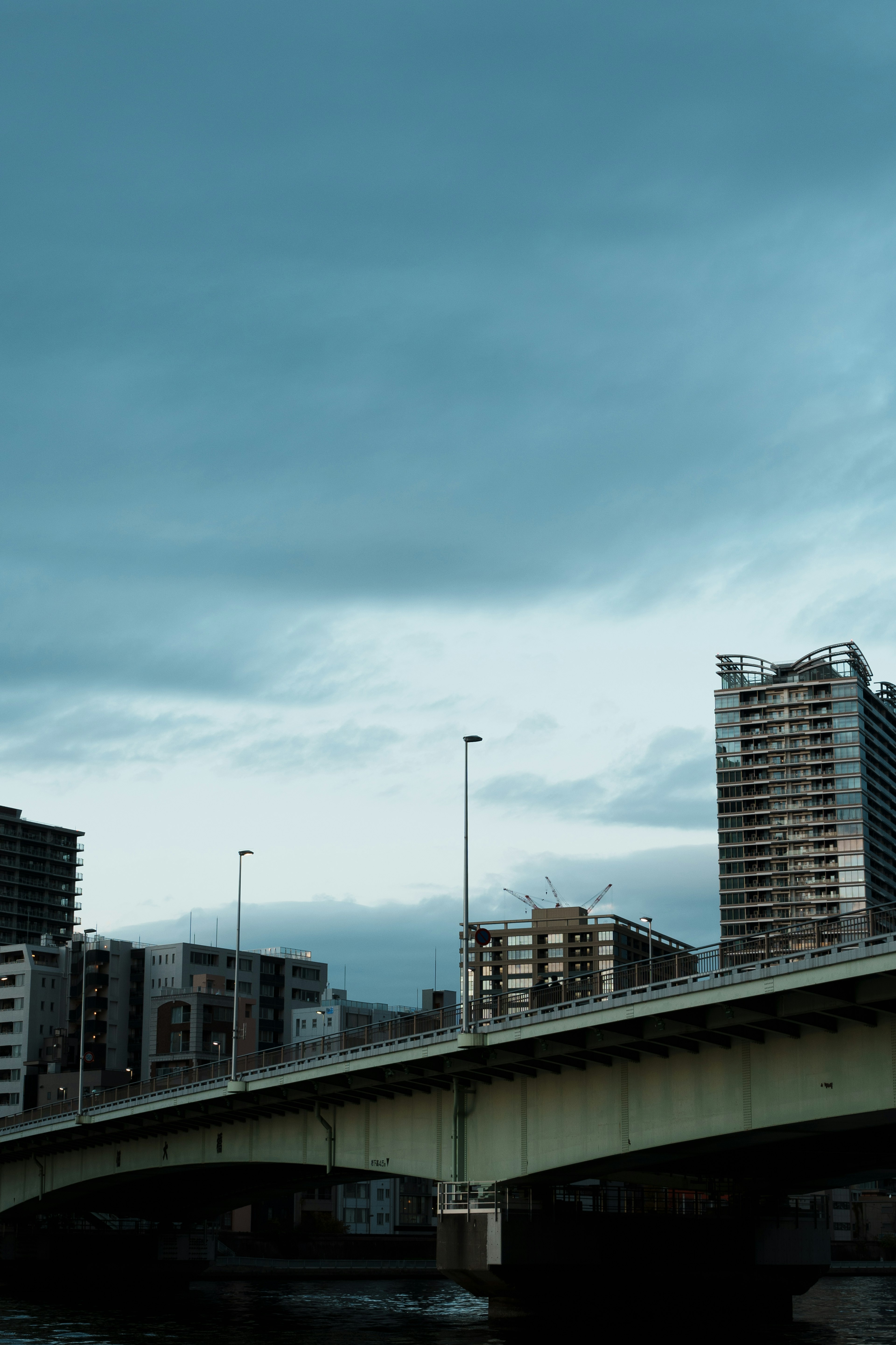 曇りの空の下に広がる都市風景と橋の写真