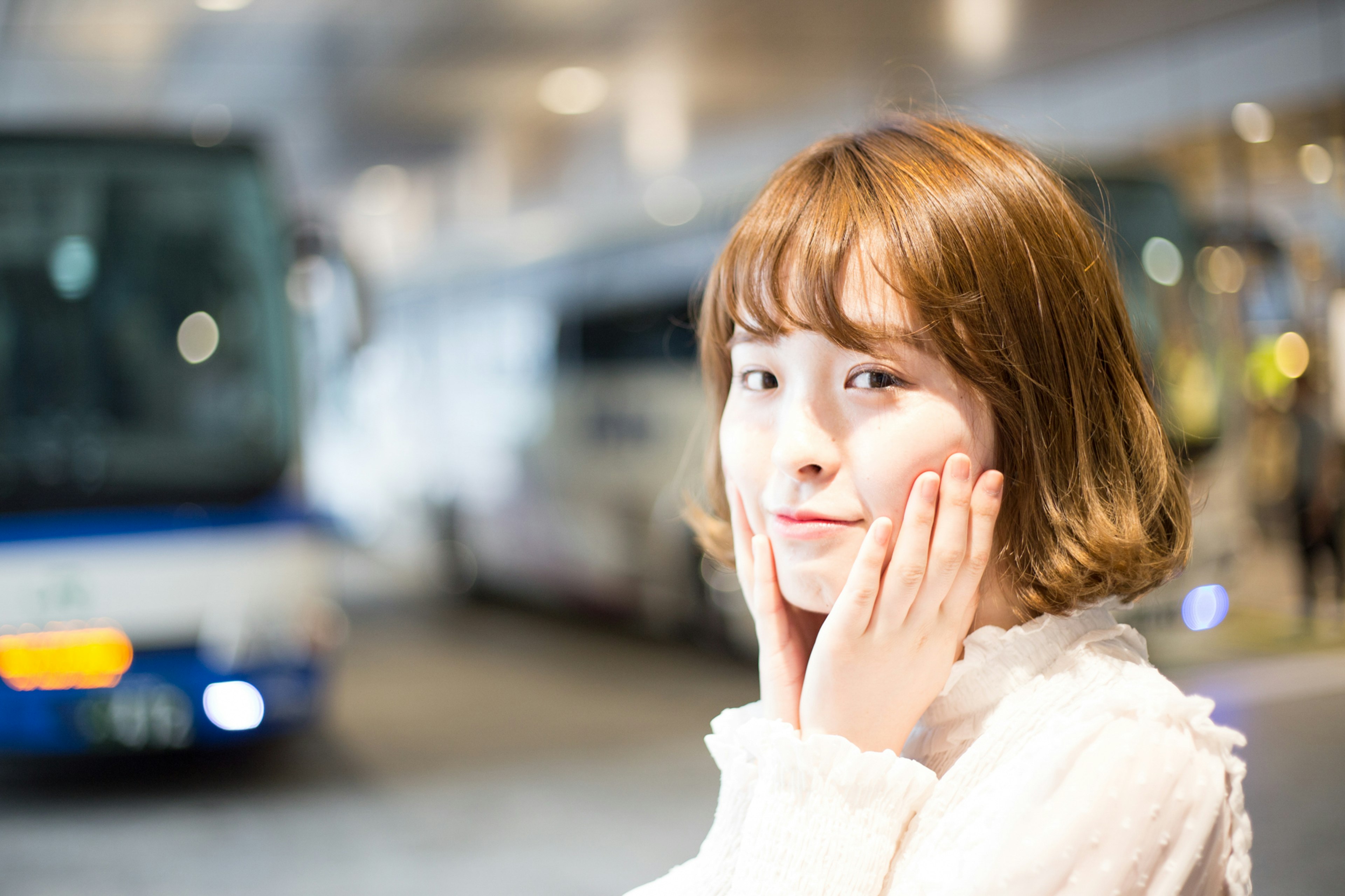 Woman with a surprised expression in front of buses