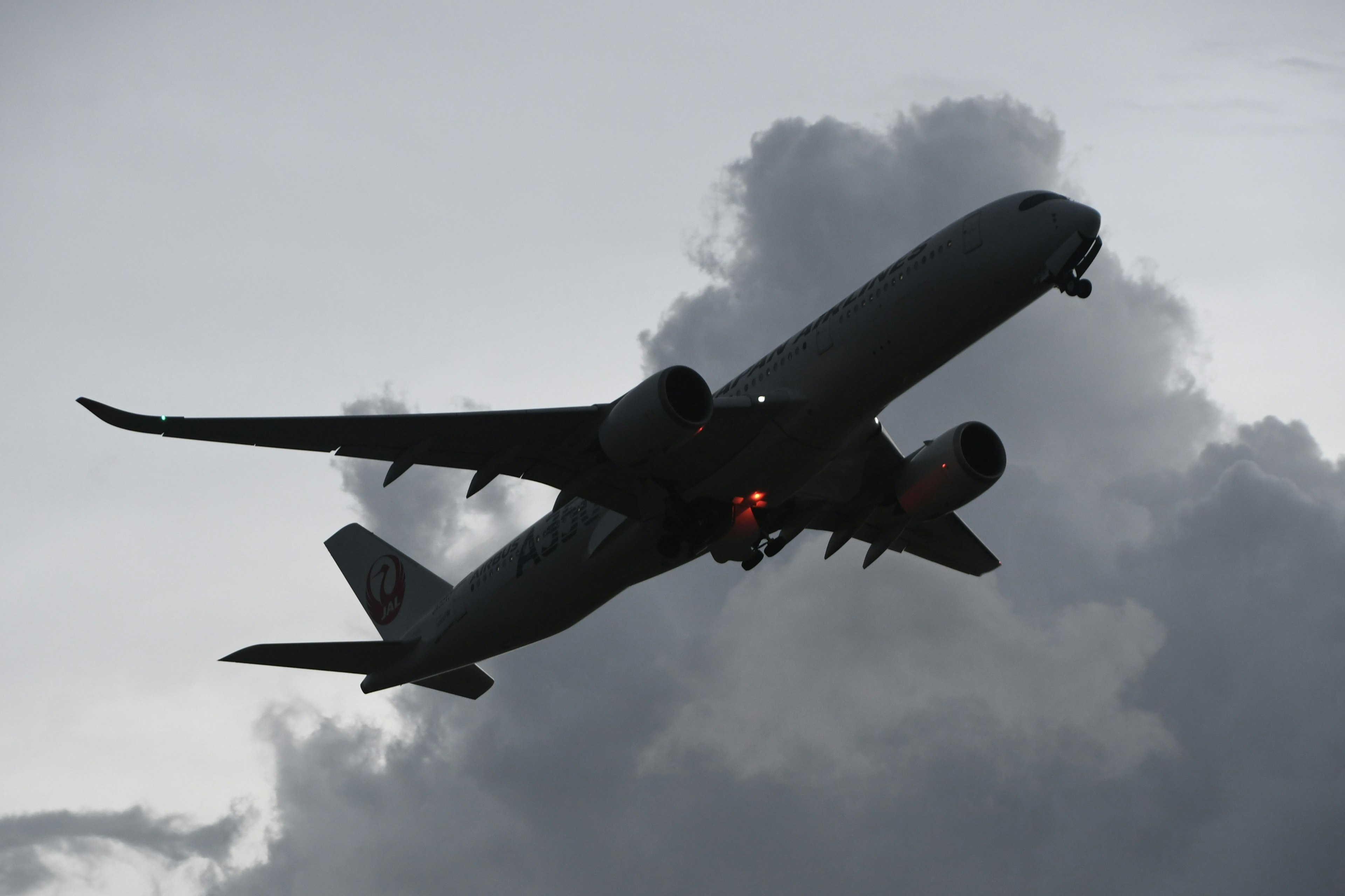 Silhouette d'un avion volant à travers les nuages