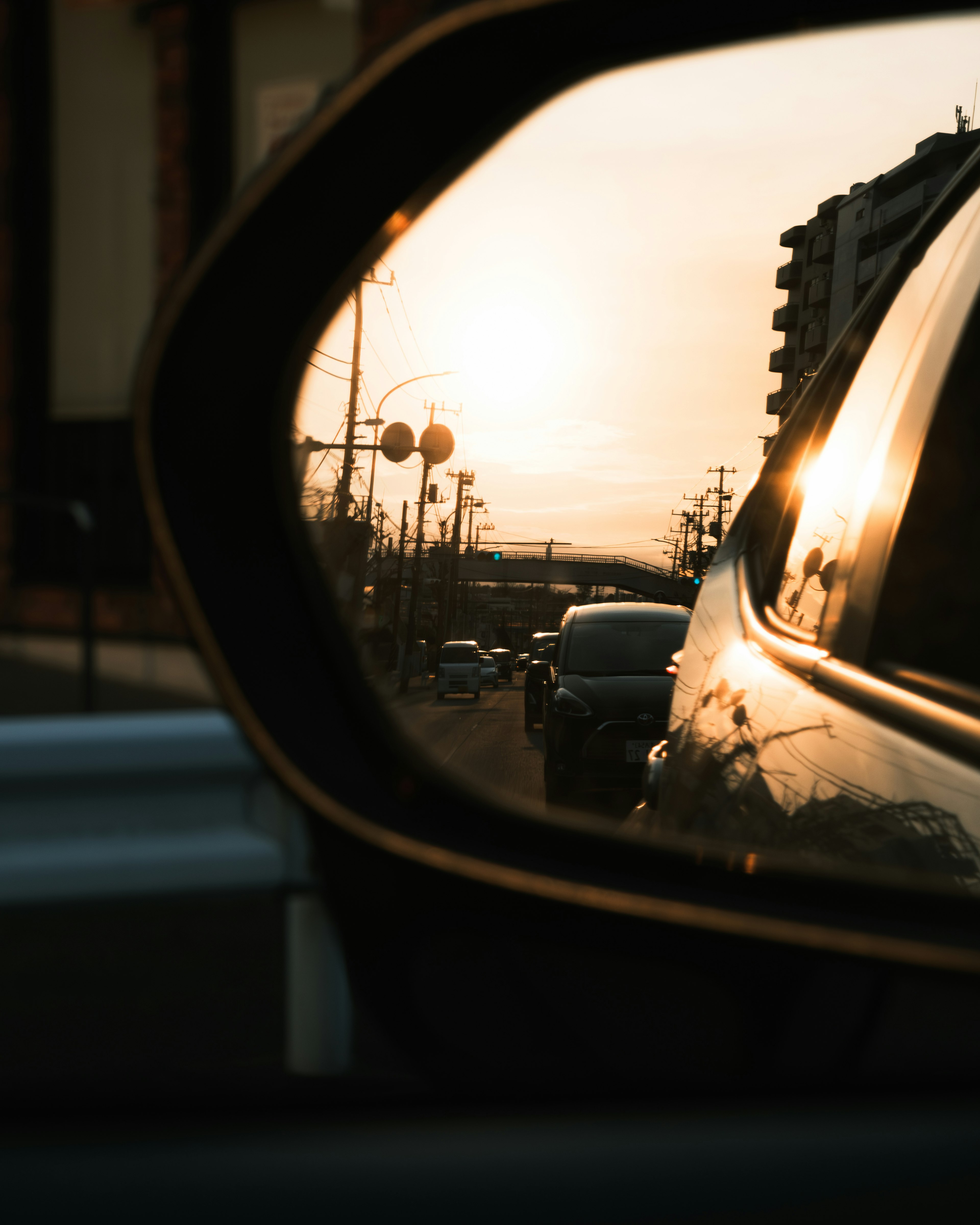 夕日が映る車のサイドミラーの写真 交通の様子が見える