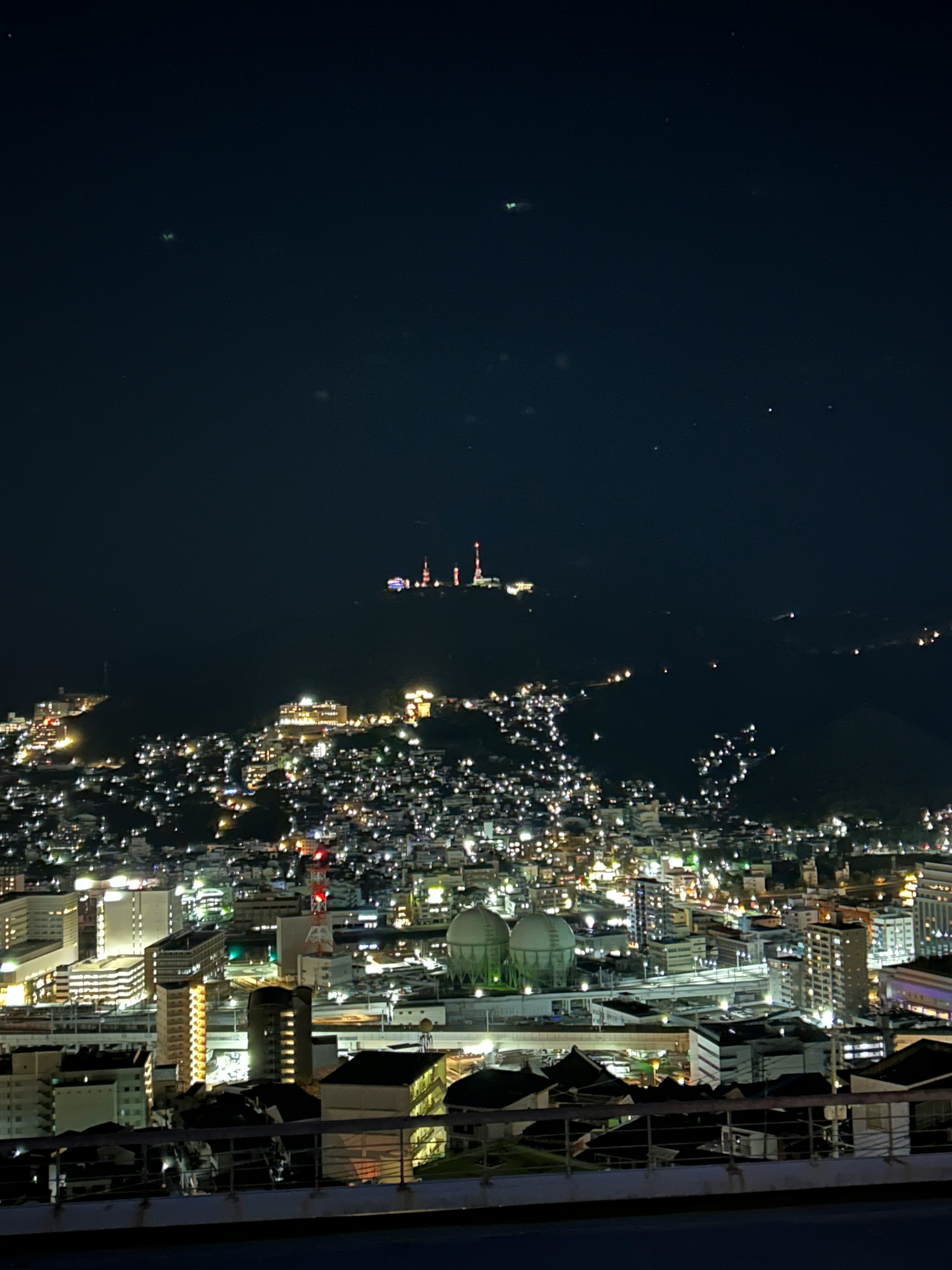 Night view of a cityscape with lights on distant hills