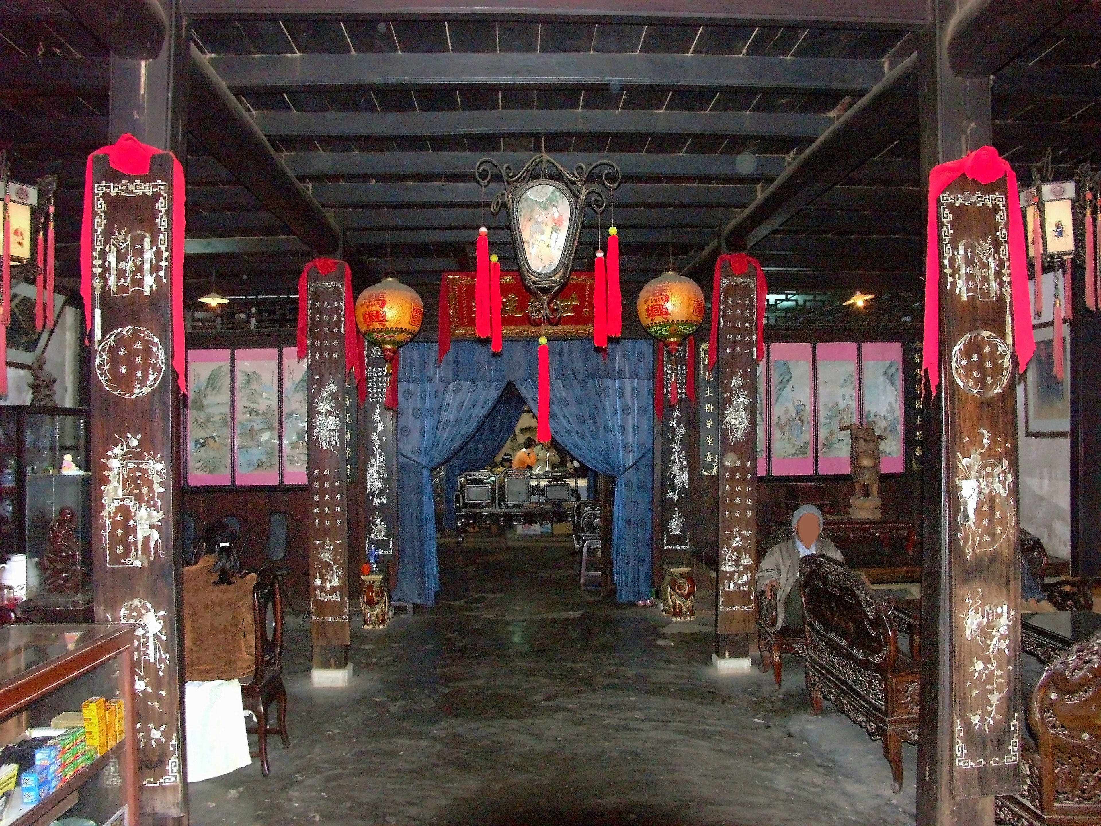 Interior de una habitación china tradicional con decoraciones rojas y columnas de madera