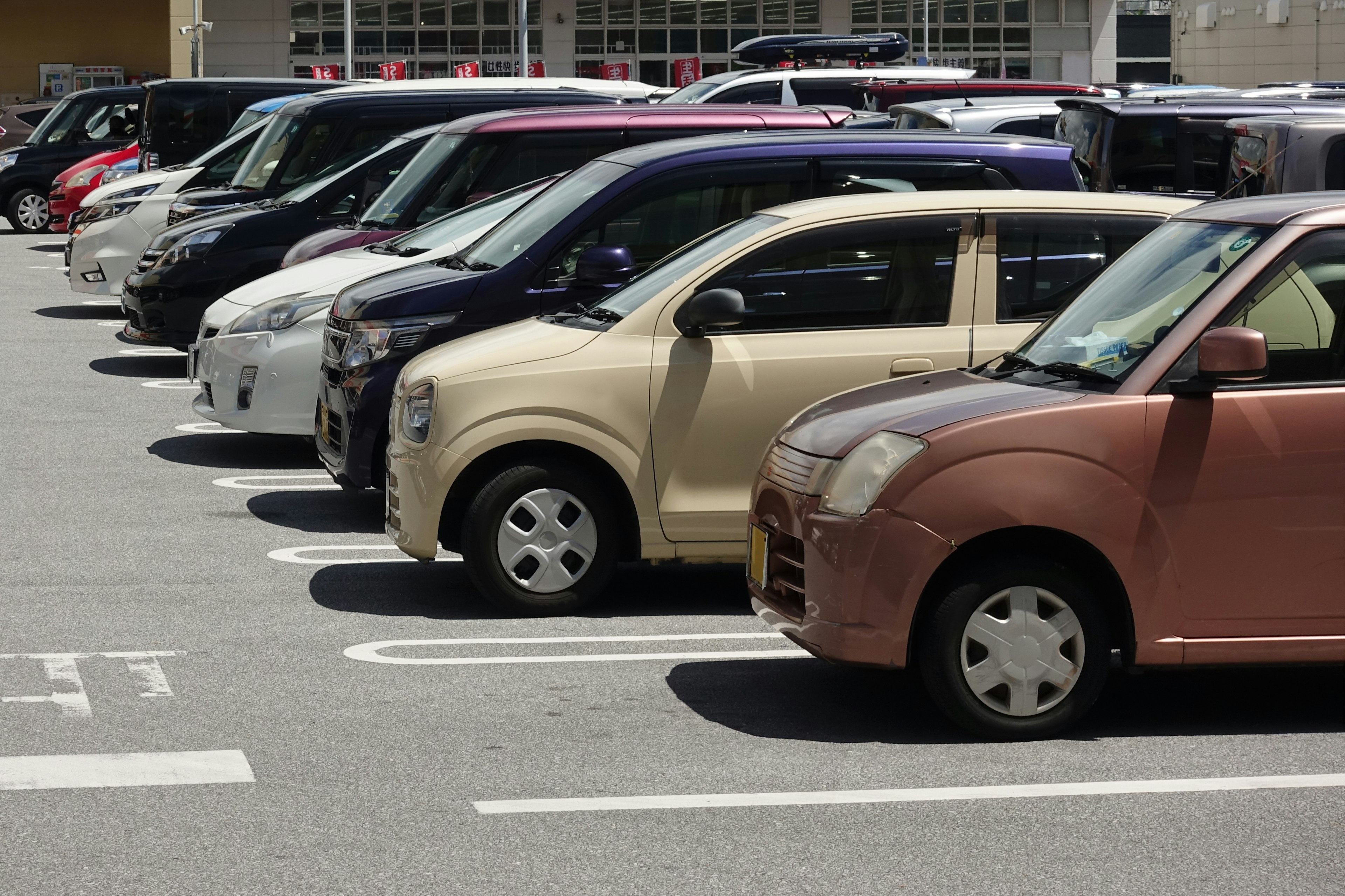 Diverse auto compatte colorate parcheggiate in un parcheggio