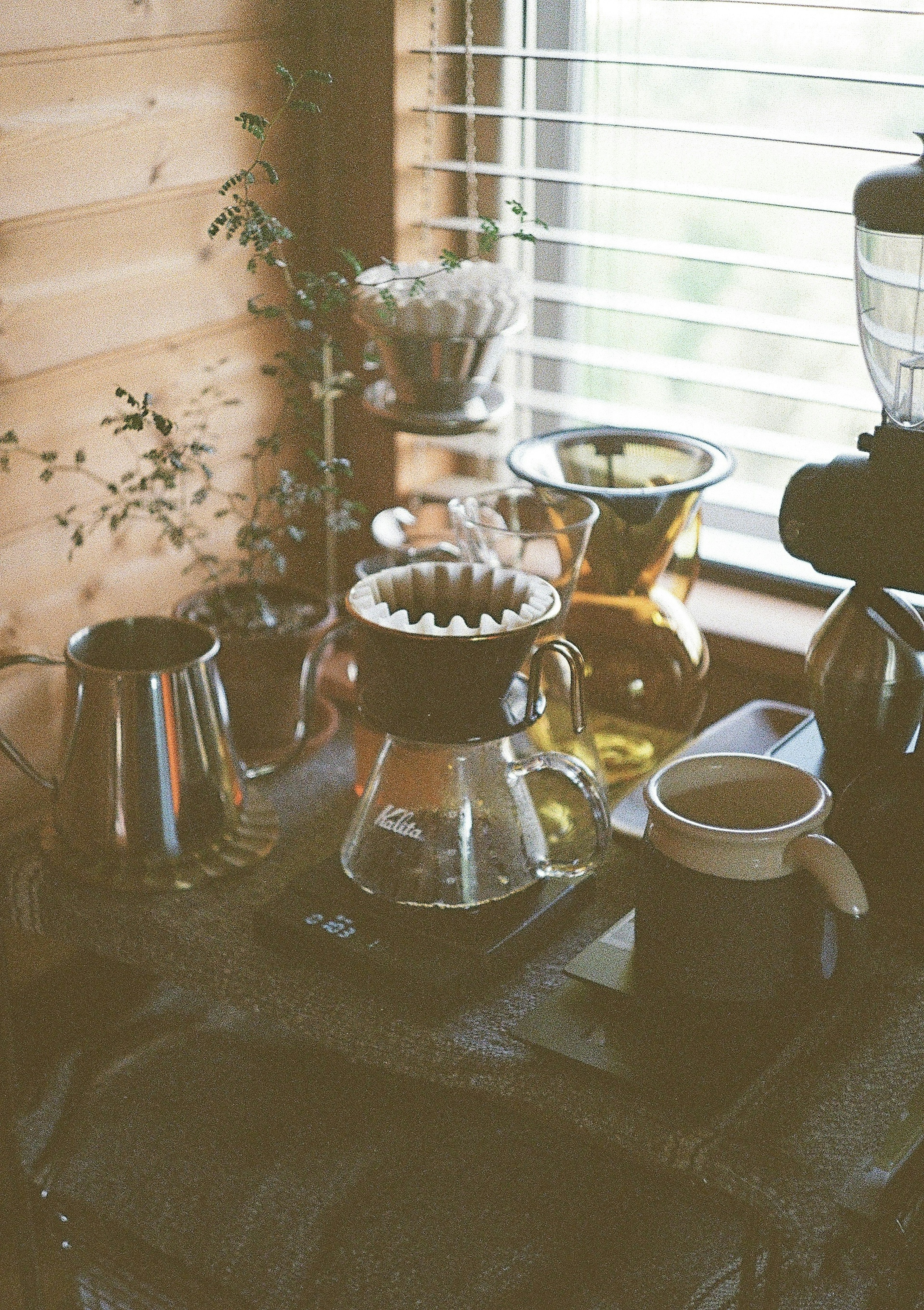 A coffee brewing setup with various tools on a windowsill