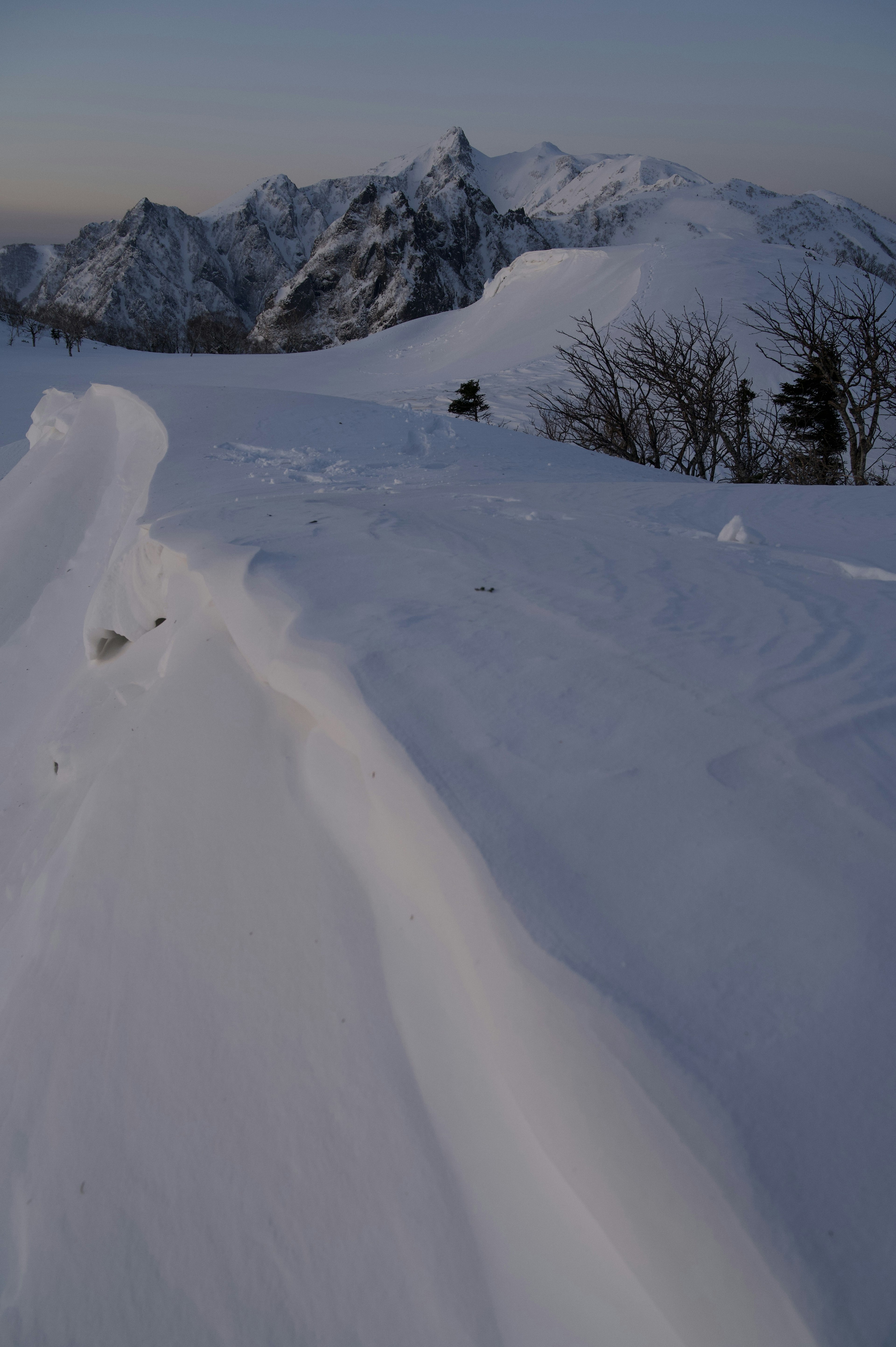 Snow-covered mountain landscape with soft evening light