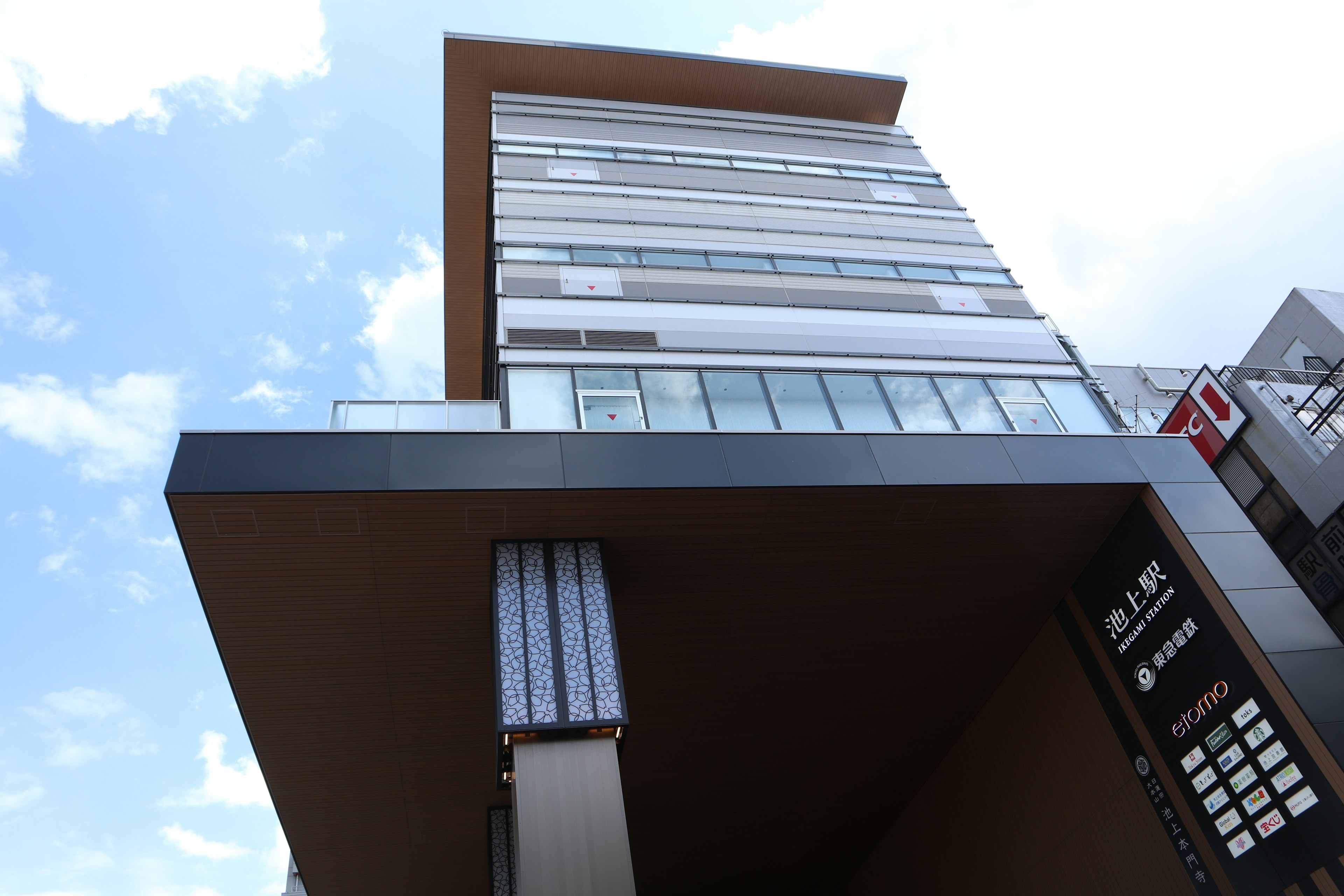 Modern building viewed from a low angle Bright blue sky with clouds in the background