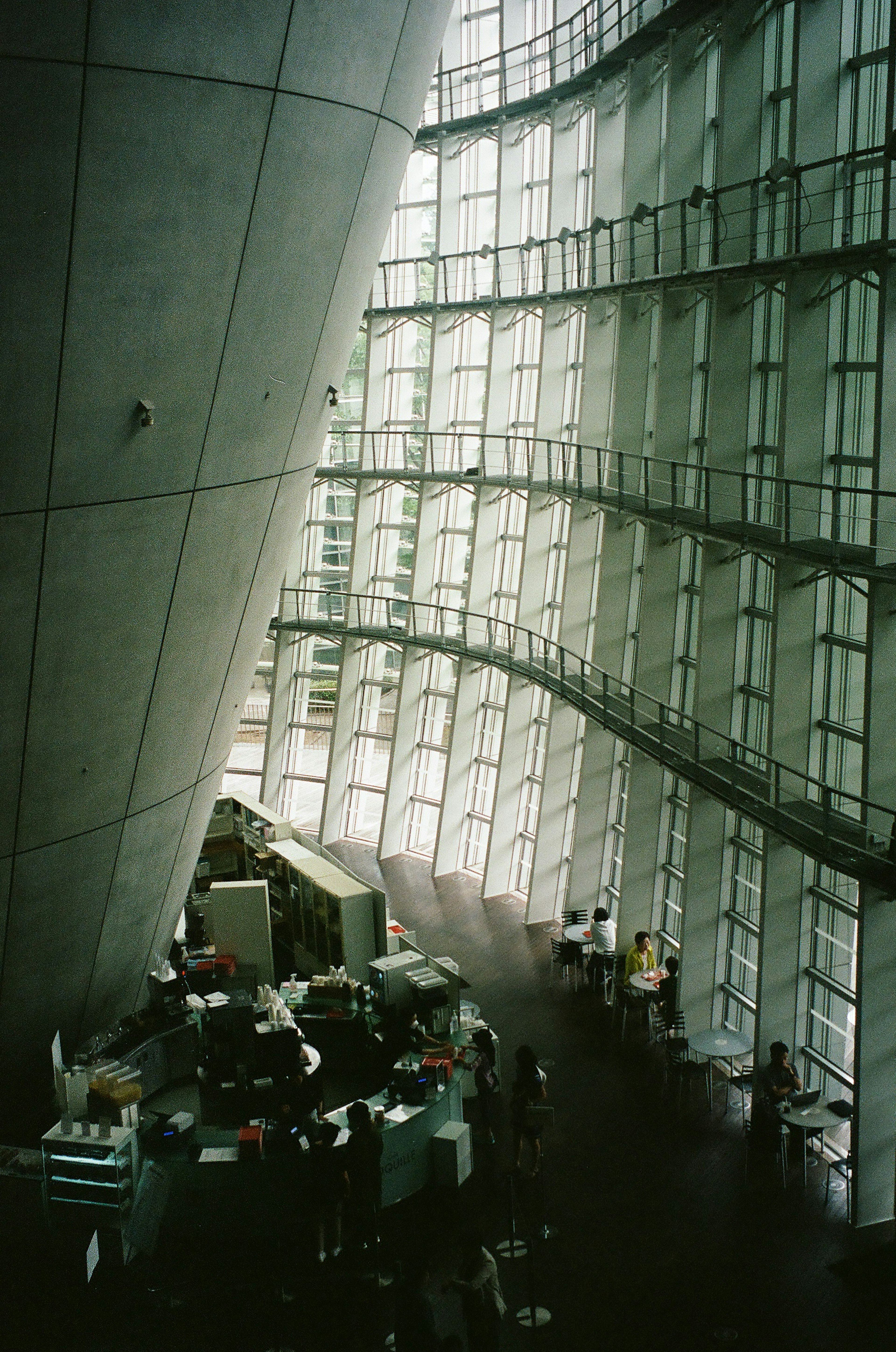 Spazio interno di un'architettura moderna con pareti in vetro curve e colonne in cemento