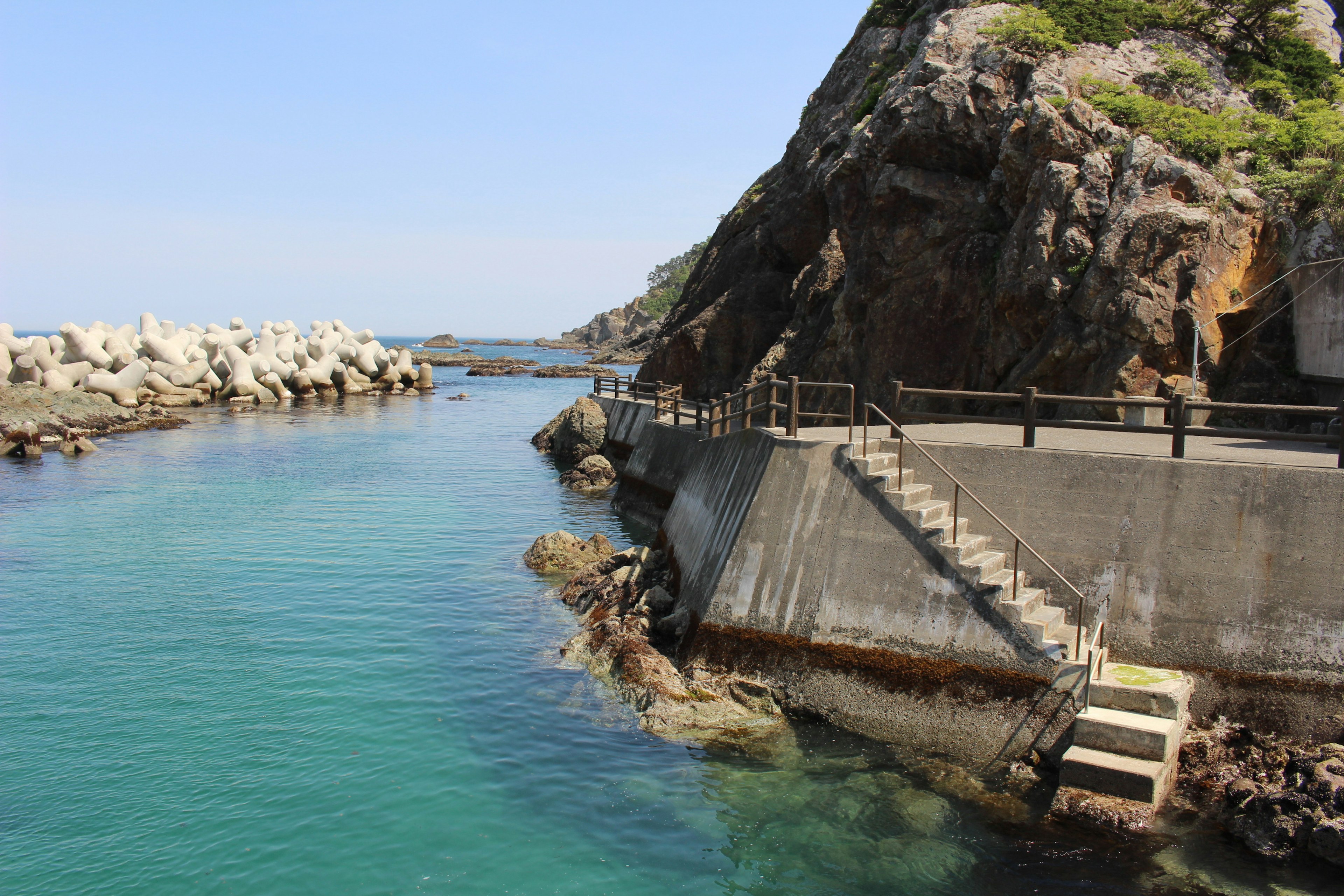 海岸风景，蓝色水域和岩石，特色是楼梯和扶手