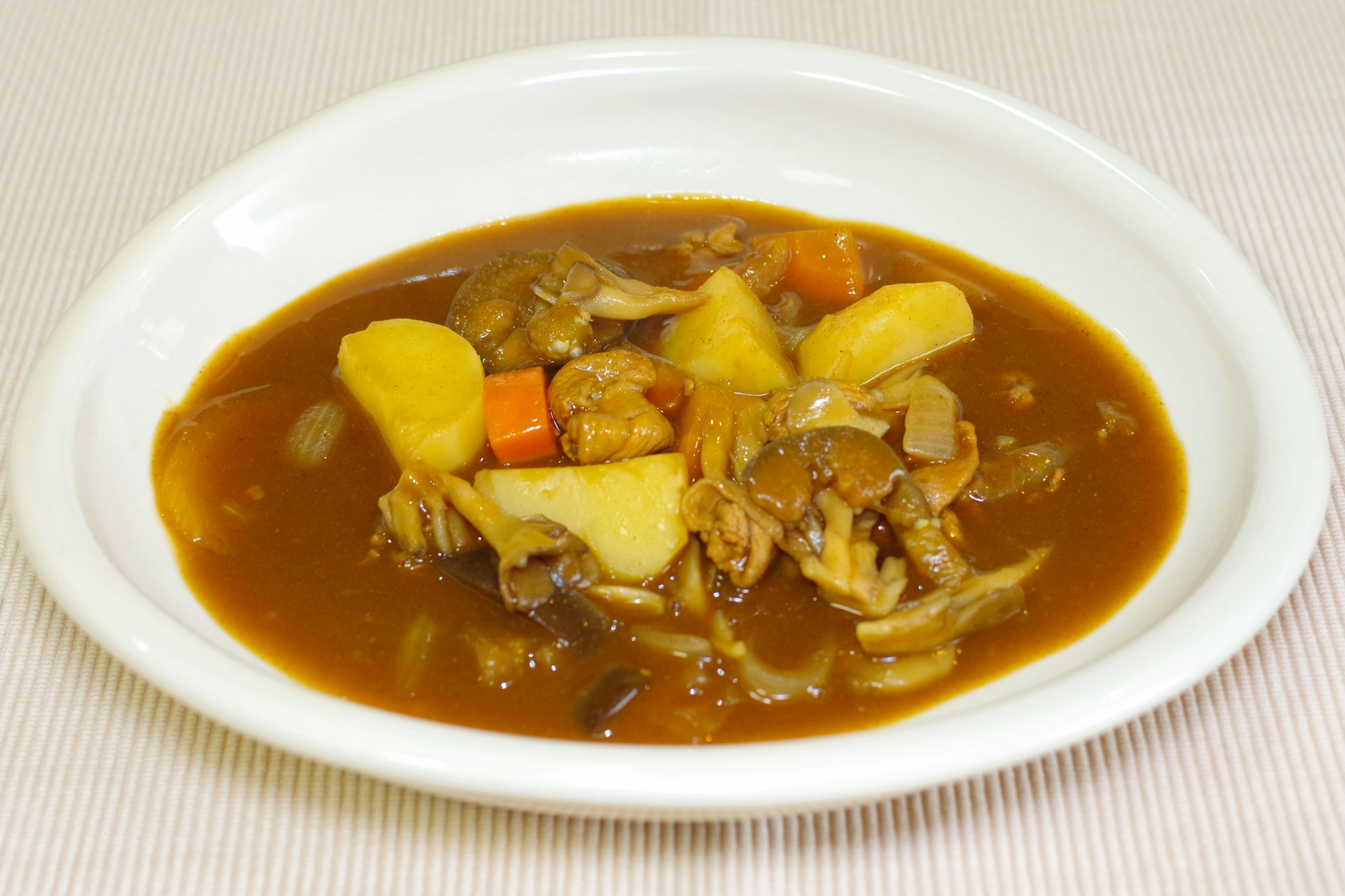 A plate of chicken and vegetables in a sweet and savory curry sauce