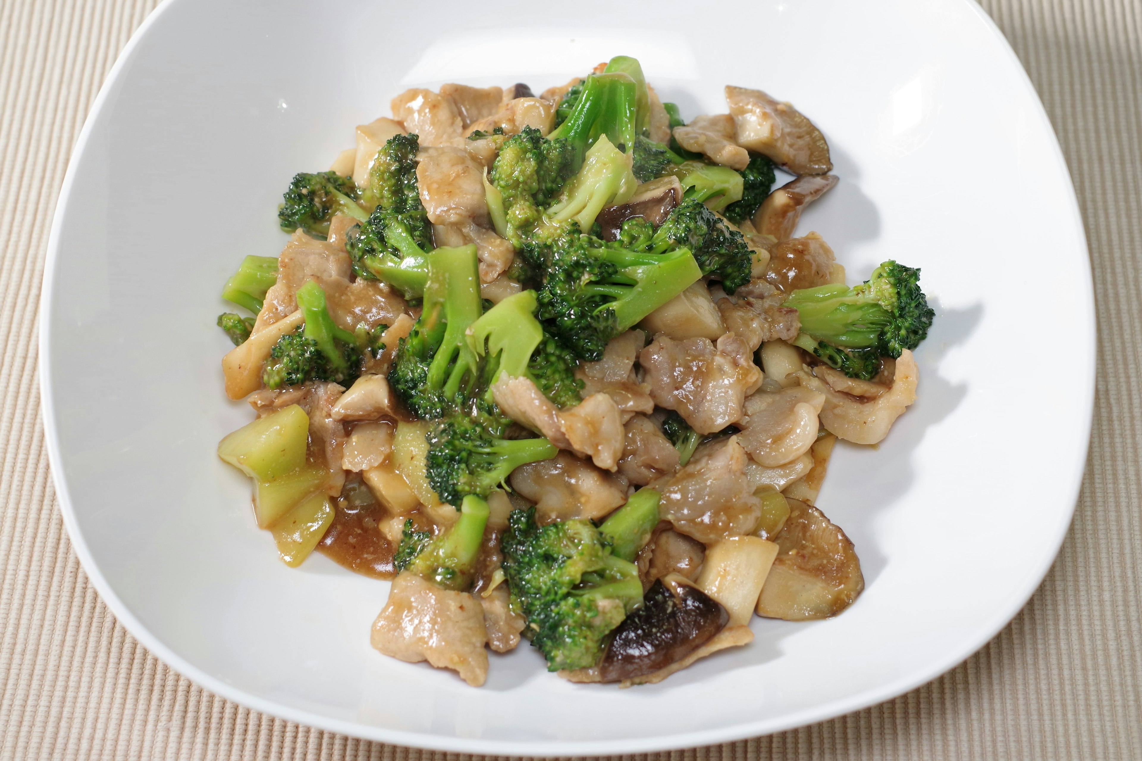 Stir-fried chicken with broccoli served in a white dish