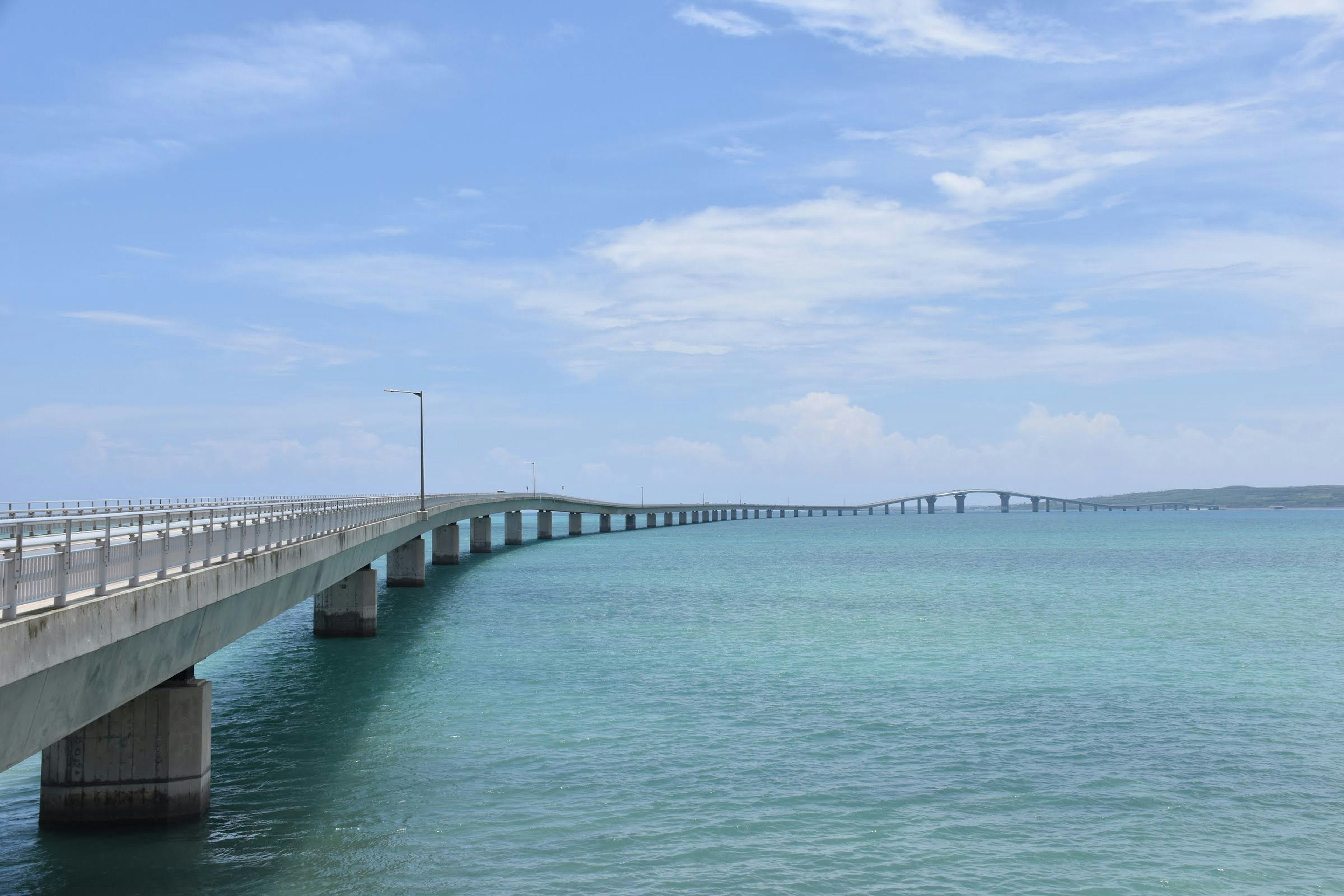 Un lungo ponte che si estende su acque turchesi sotto un cielo blu