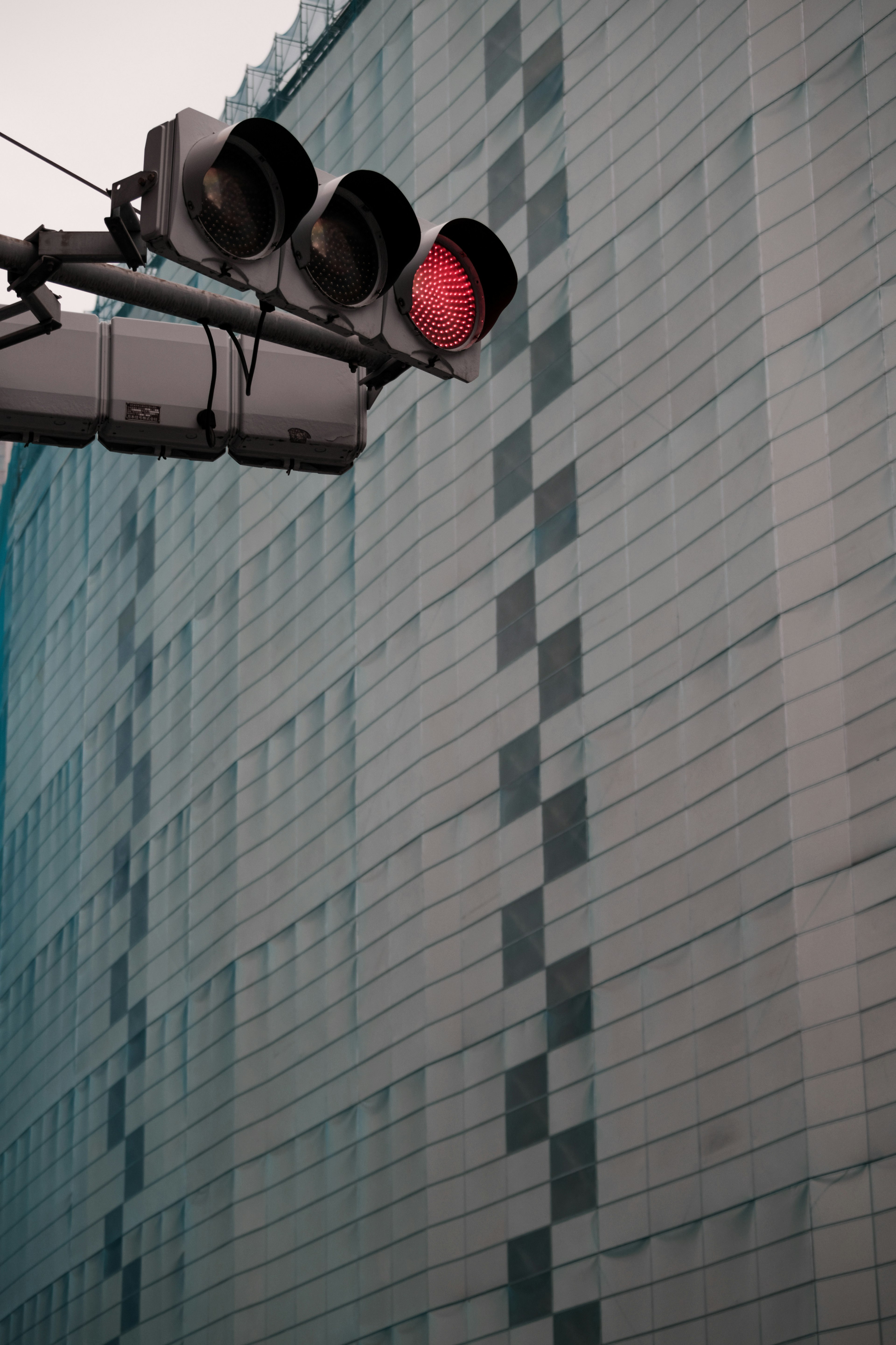 Semáforo en rojo frente a una fachada de edificio moderno