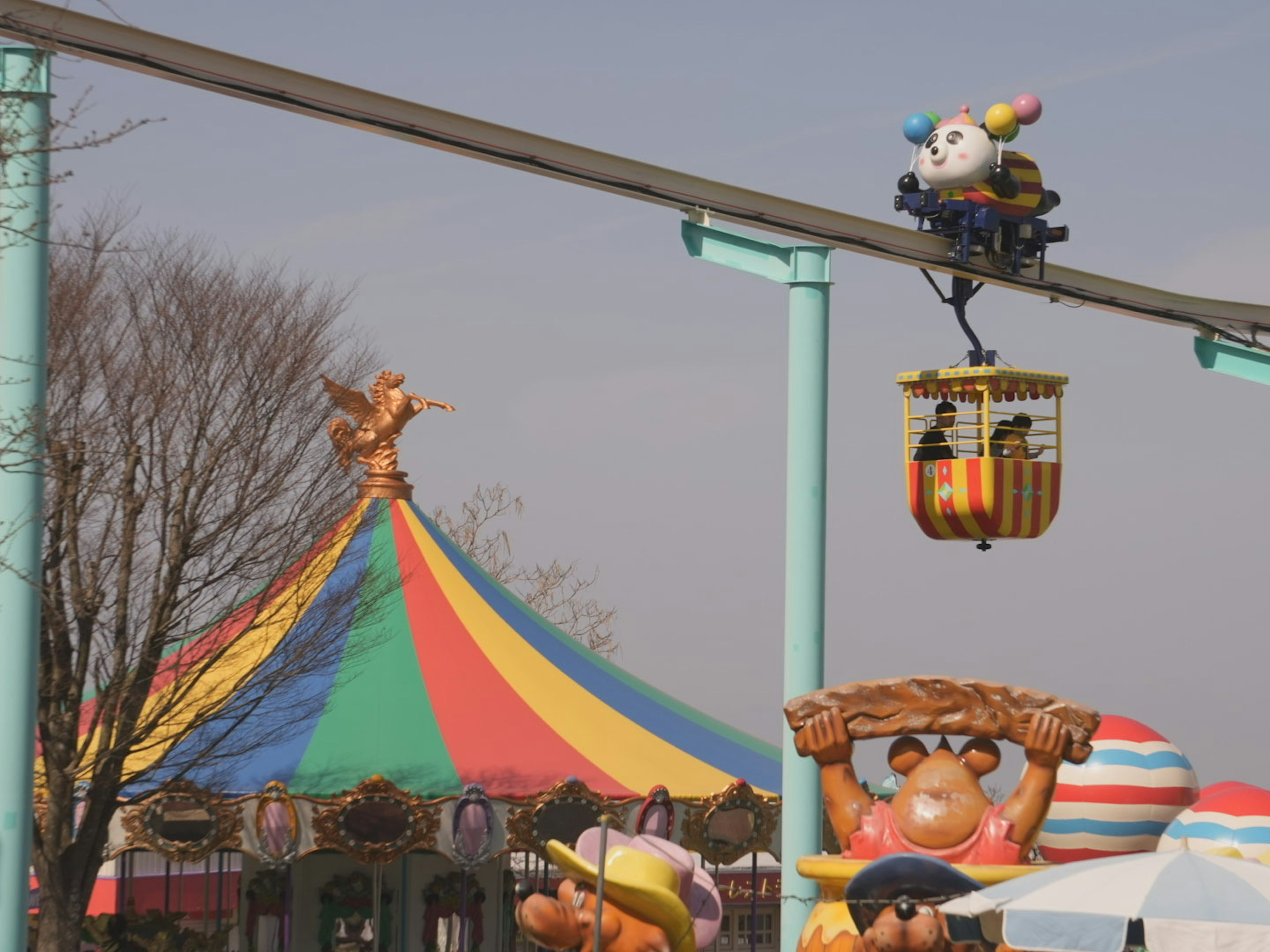 Carpa colorida de parque de atracciones con monorraíl y personajes