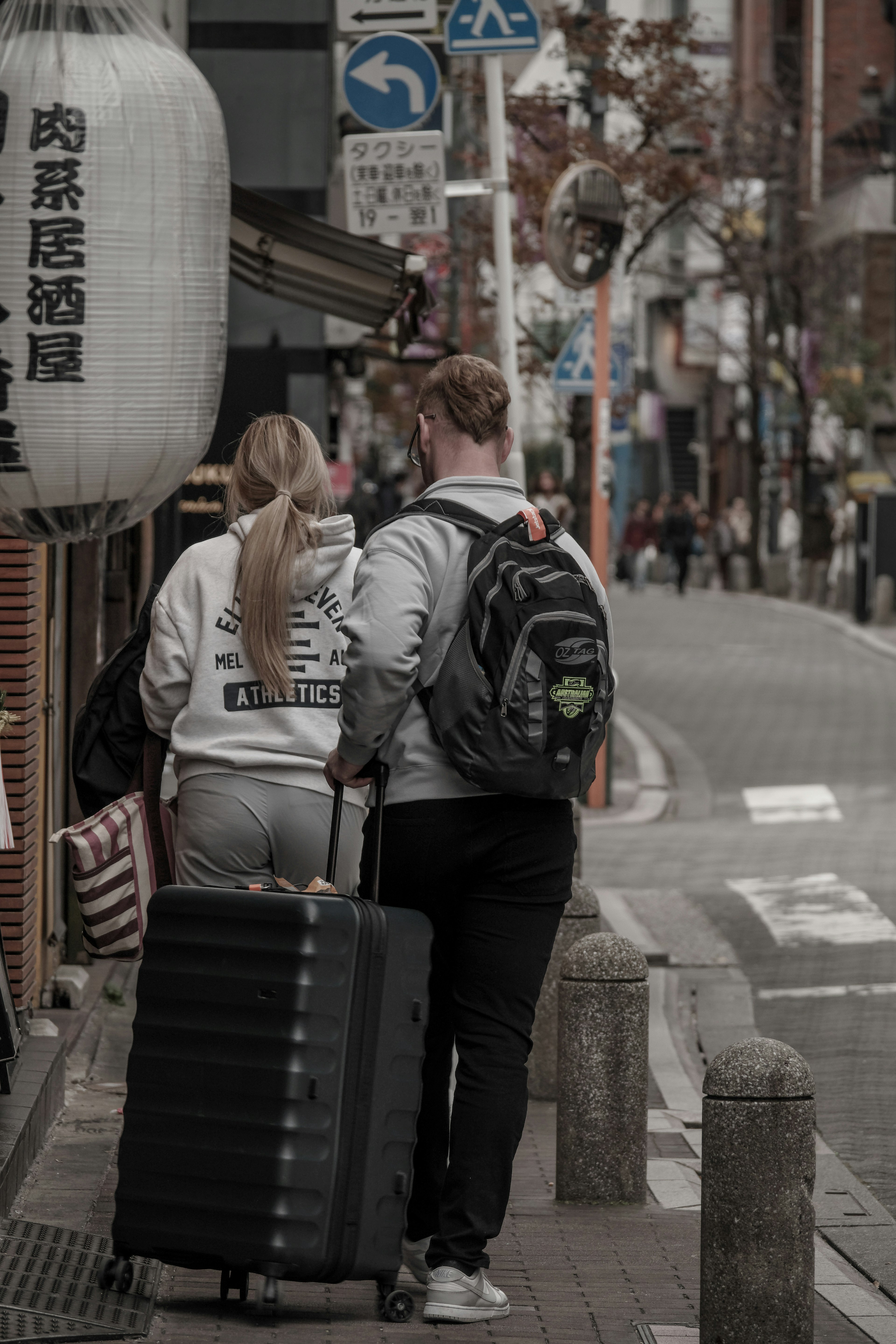 旅行中のカップルがスーツケースを引いている街の風景