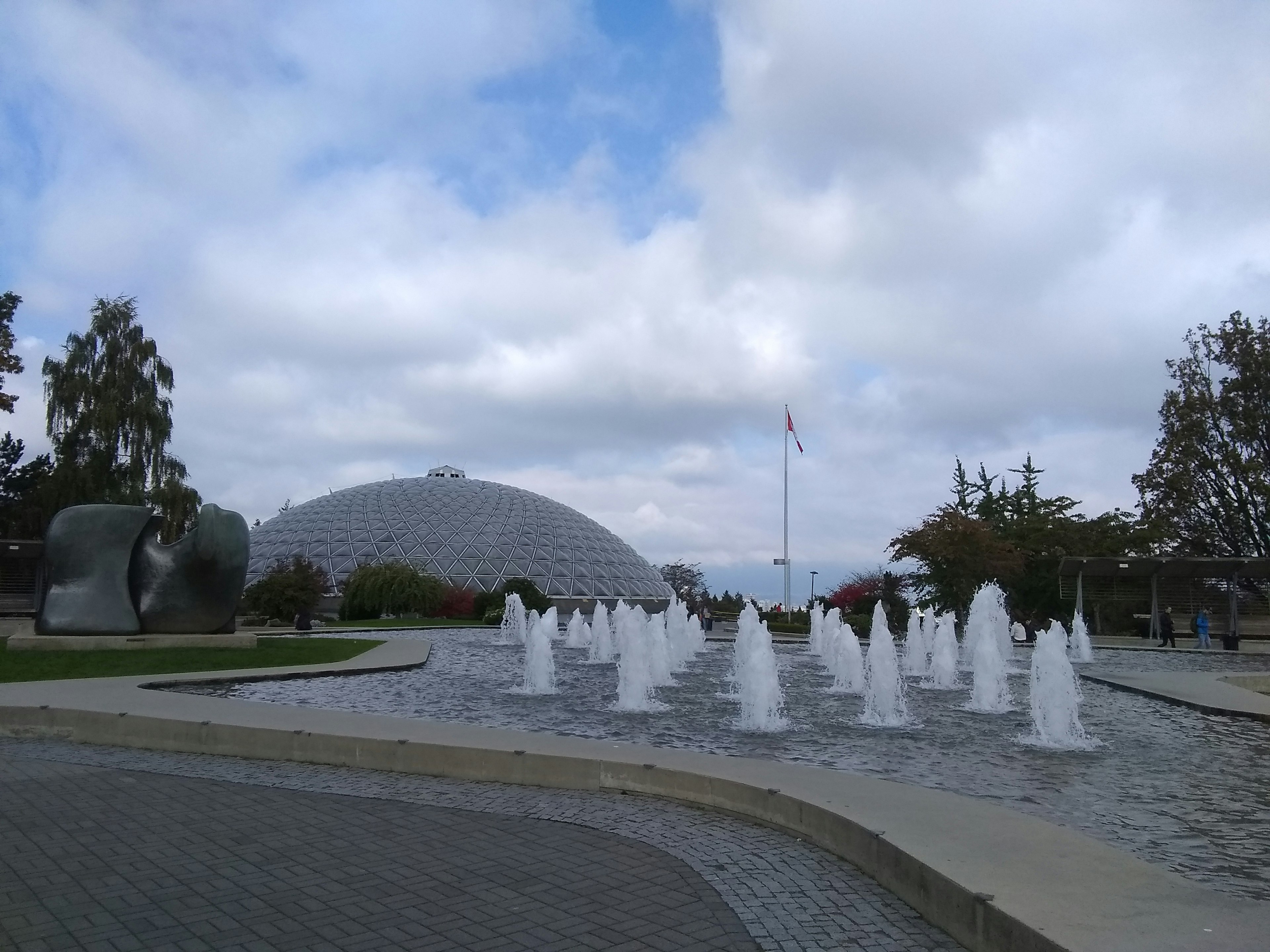 Park scene featuring fountains and a dome-shaped building