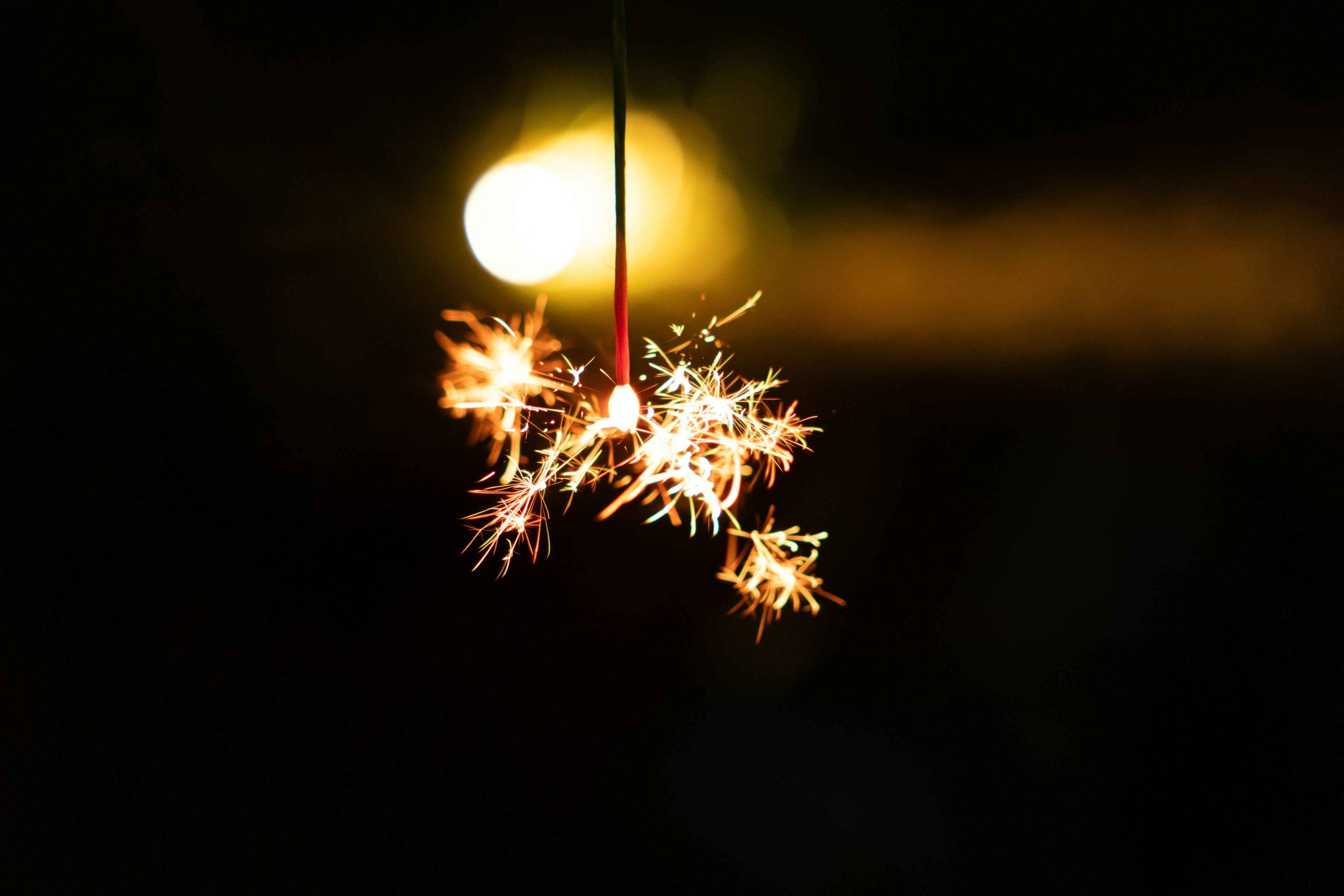 Image of a sparkling firework sparkler against a dark background