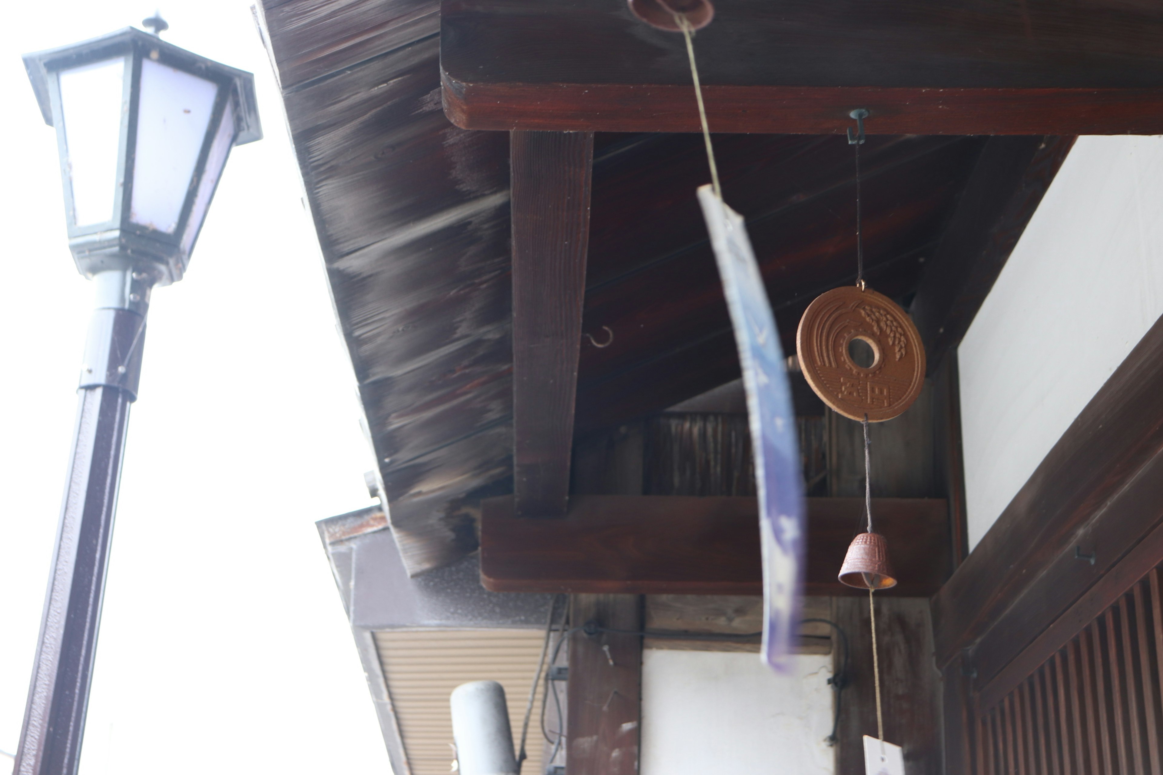 Casa japonesa tradicional con campanas de viento y una farola