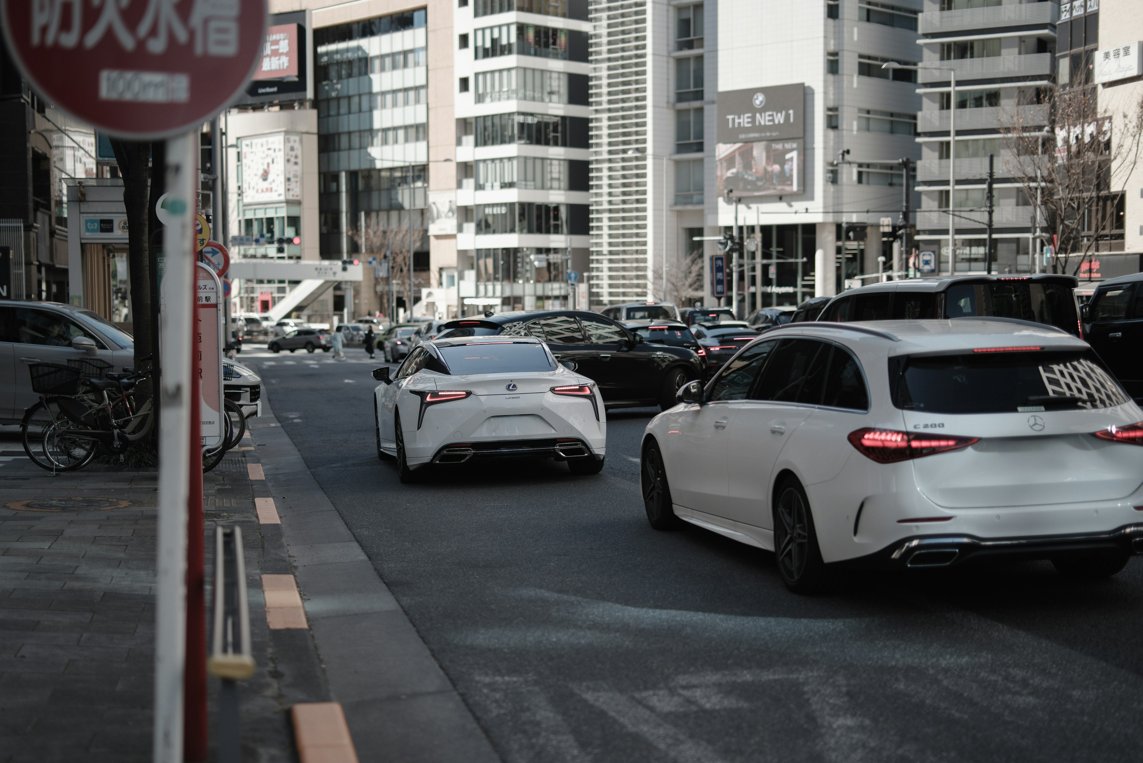 White cars on a city street with modern buildings