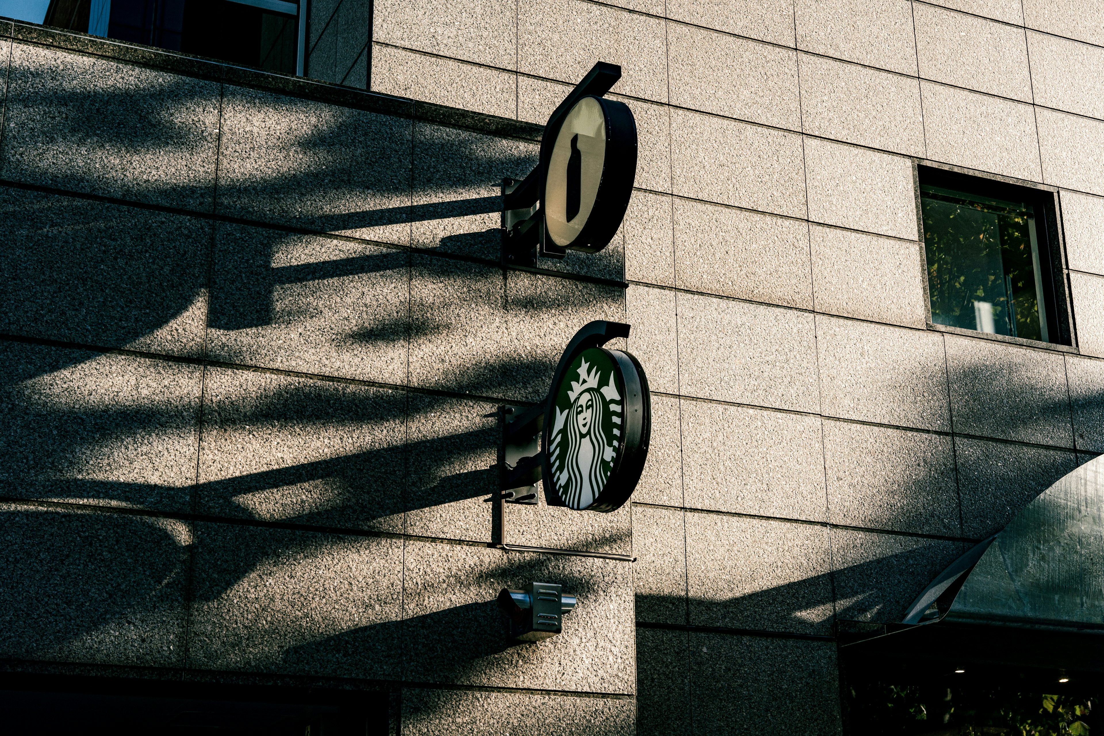 Logo de Starbucks y sombras en la fachada de un edificio