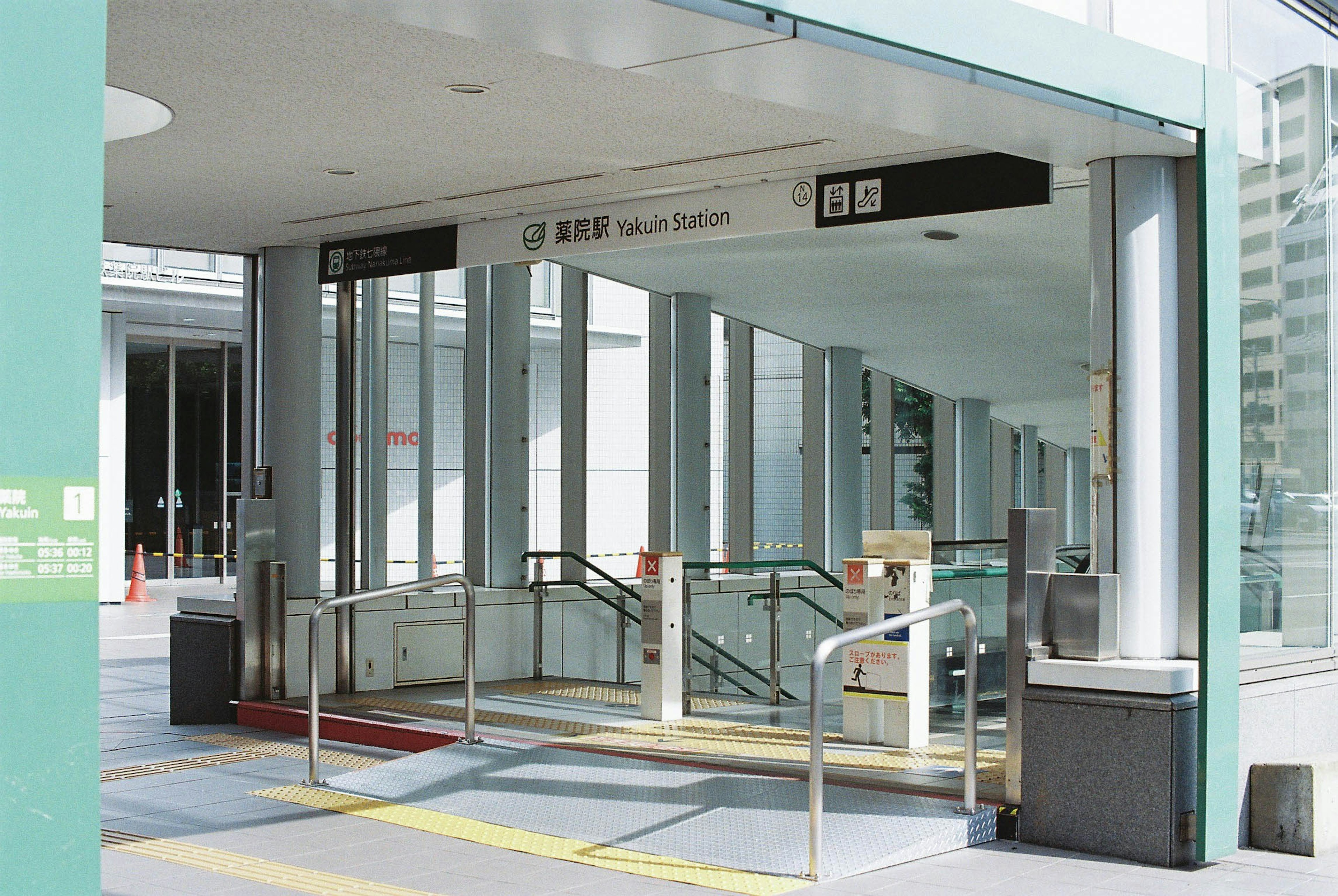 View of a building entrance featuring a train station sign and stairs with railings