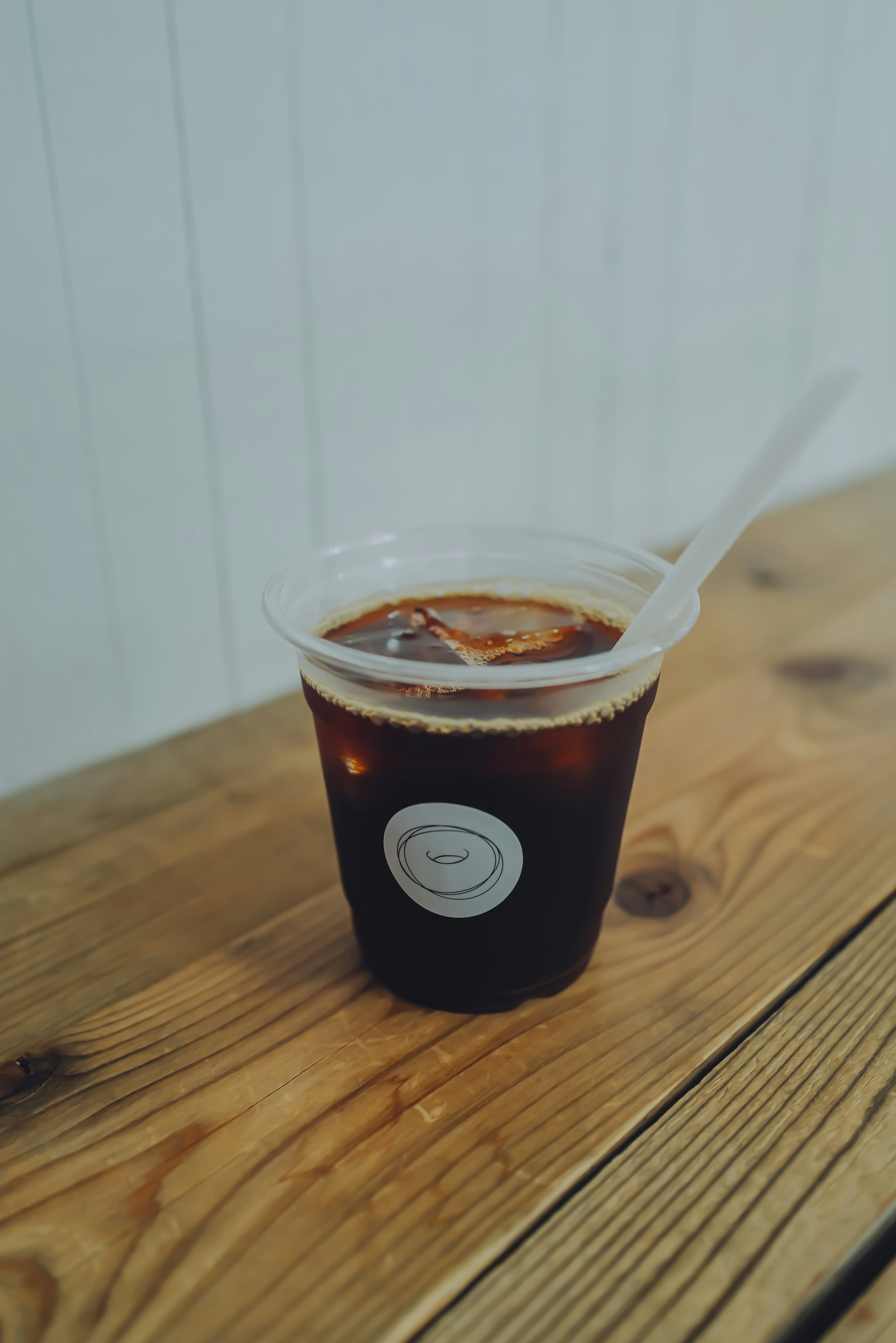 Café helado en un vaso de plástico transparente con una pajilla