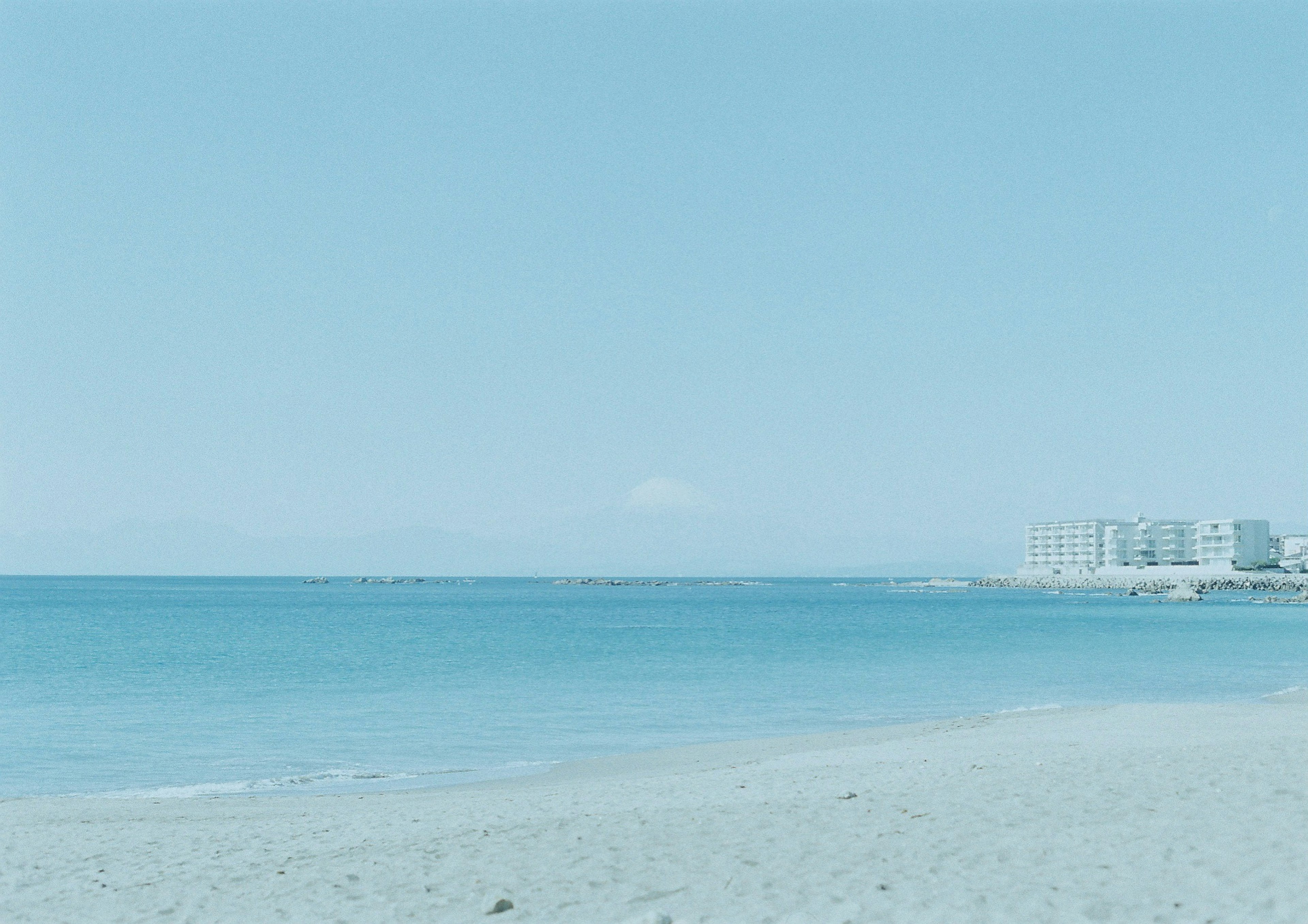 青い海と砂浜の風景と遠くの建物