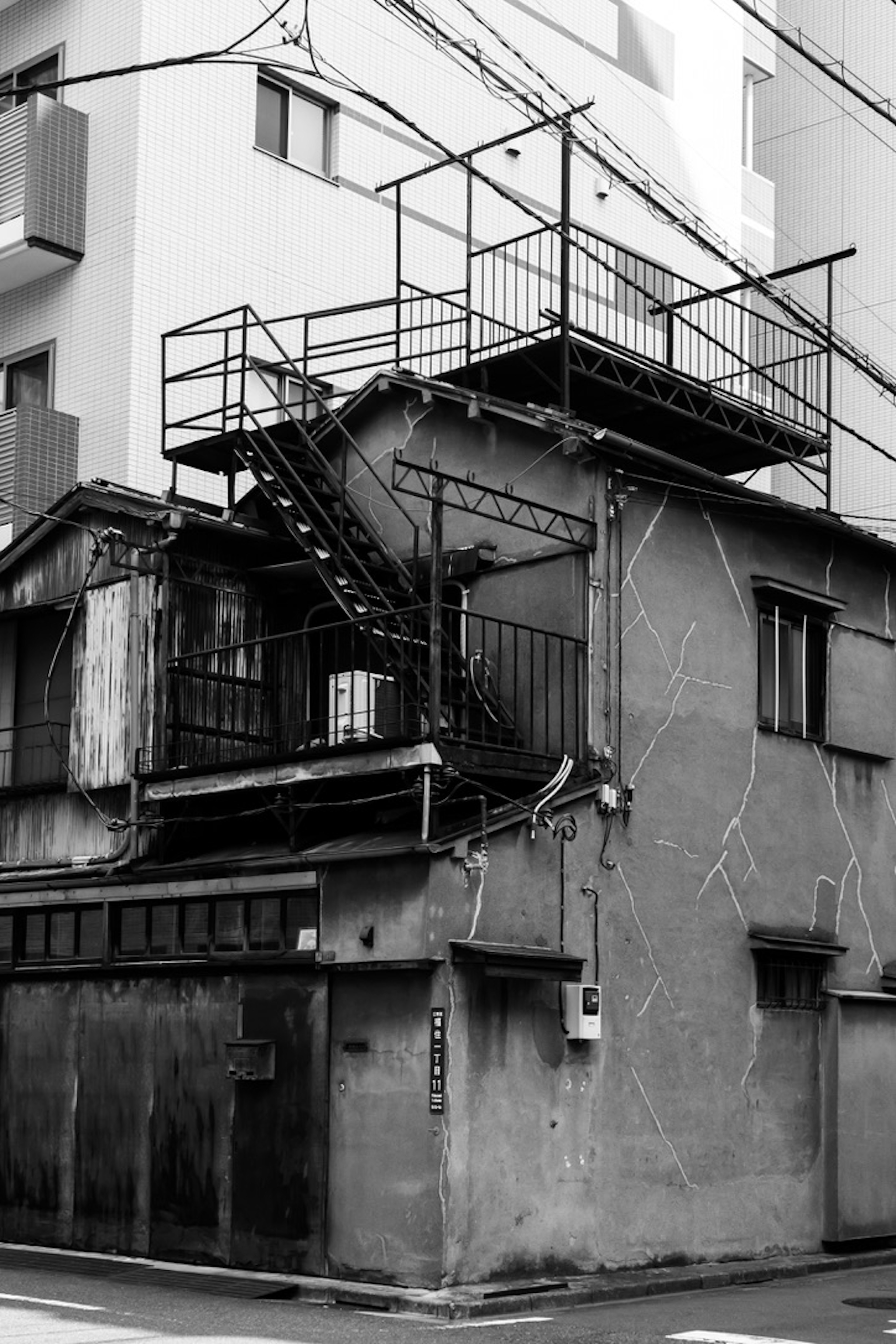 Bâtiment usé avec un escalier dans une photo en noir et blanc