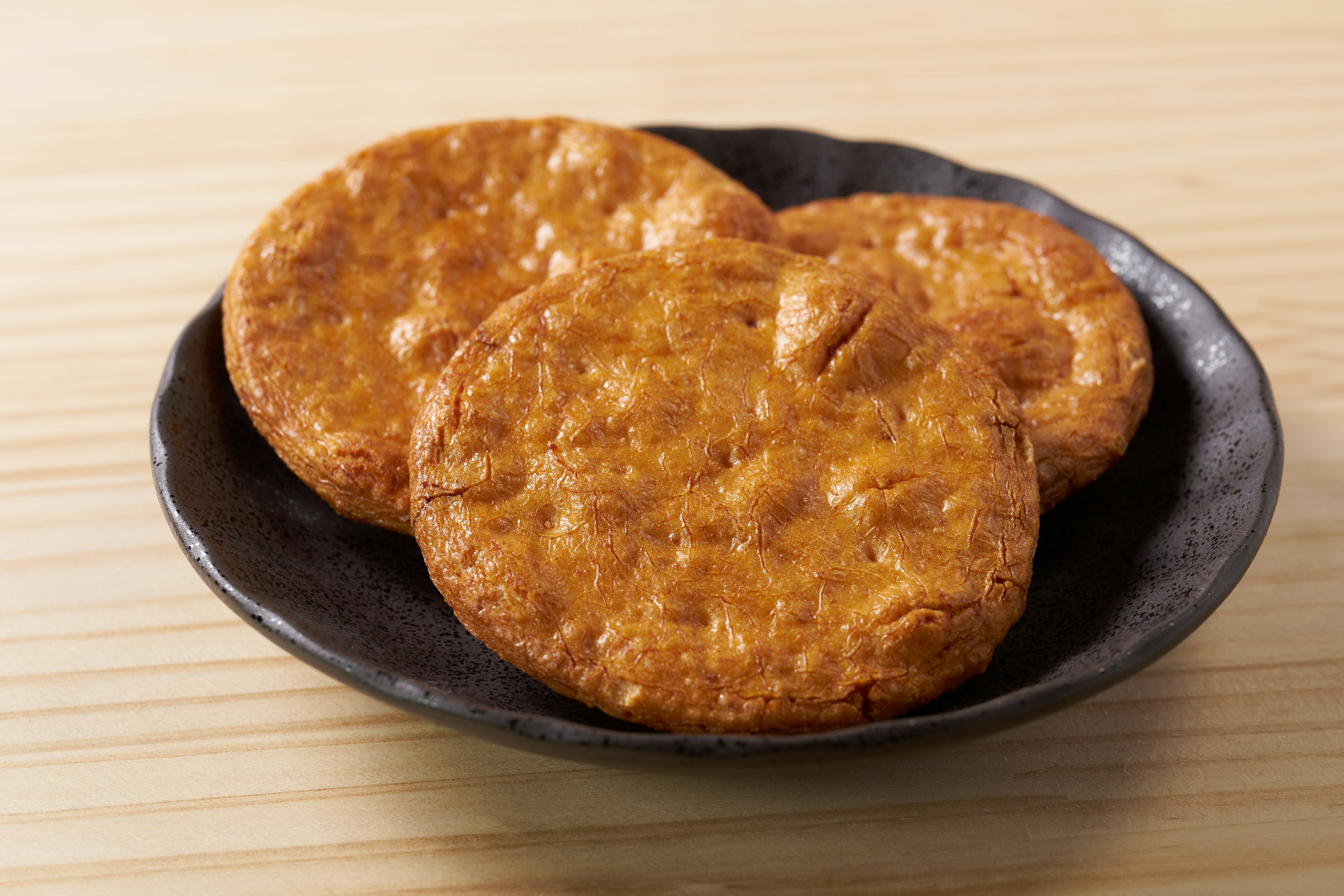 Three crispy cookies on a black plate