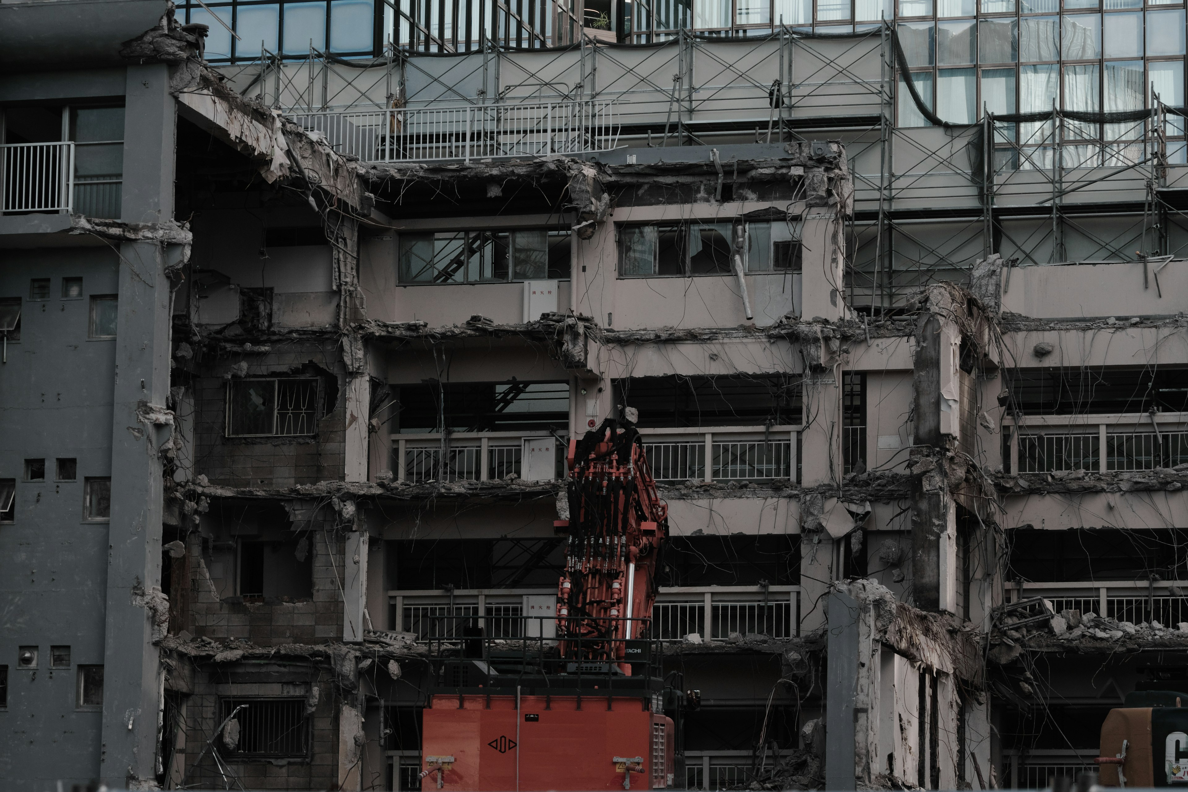 Facade of a damaged building with heavy machinery in operation