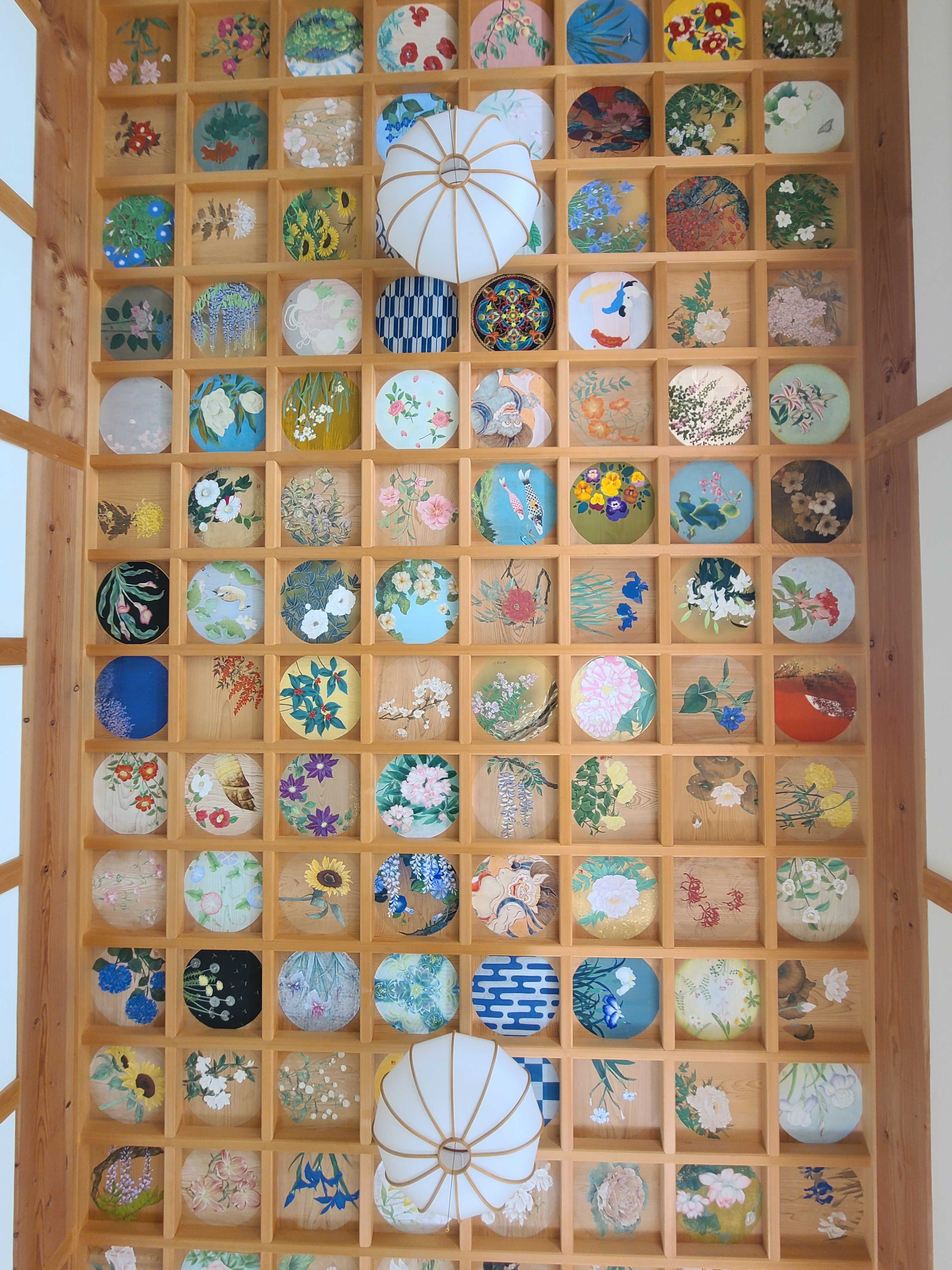 Wooden wall displaying a variety of decorative plates with intricate patterns