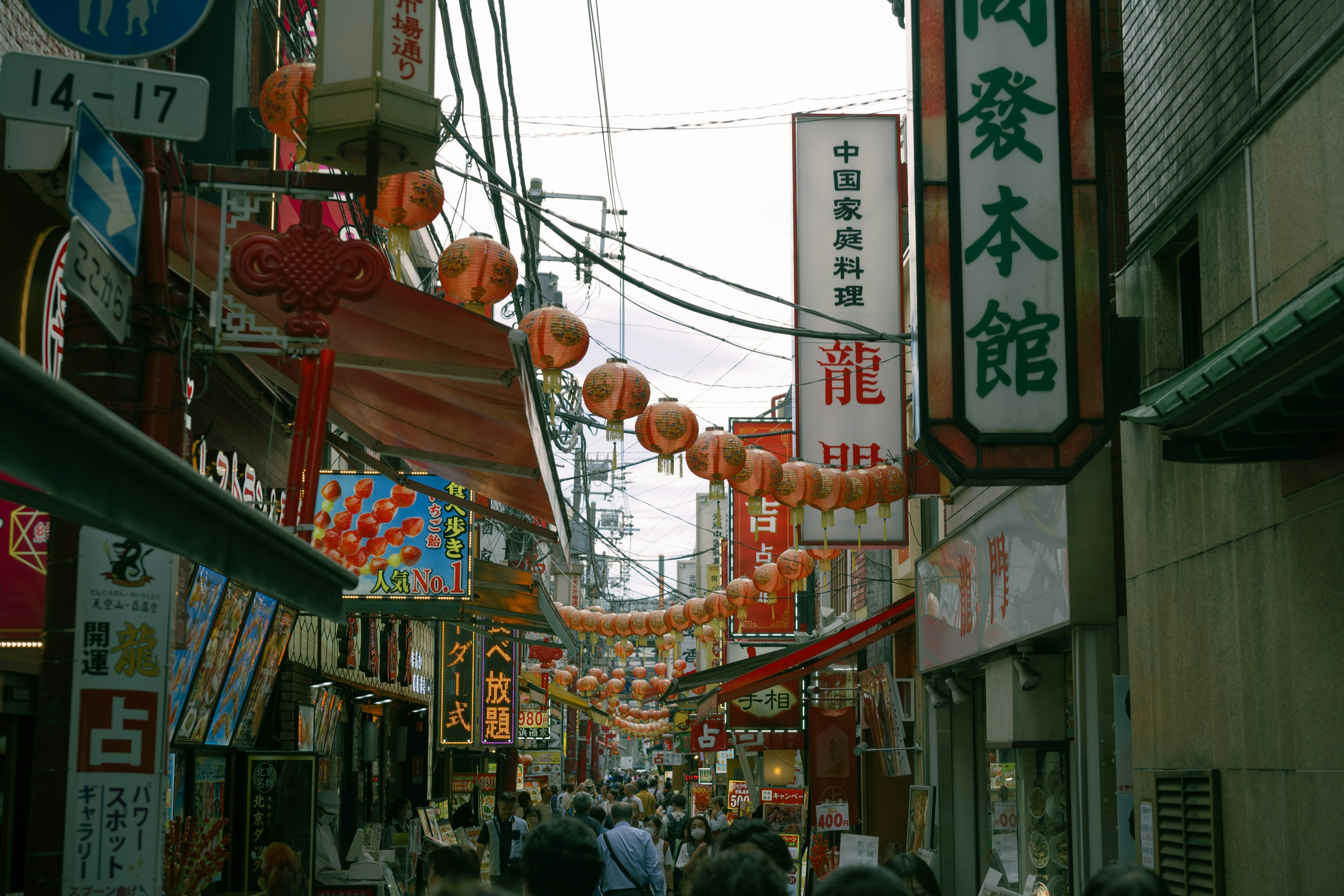 Busy shopping street adorned with lanterns and colorful signs