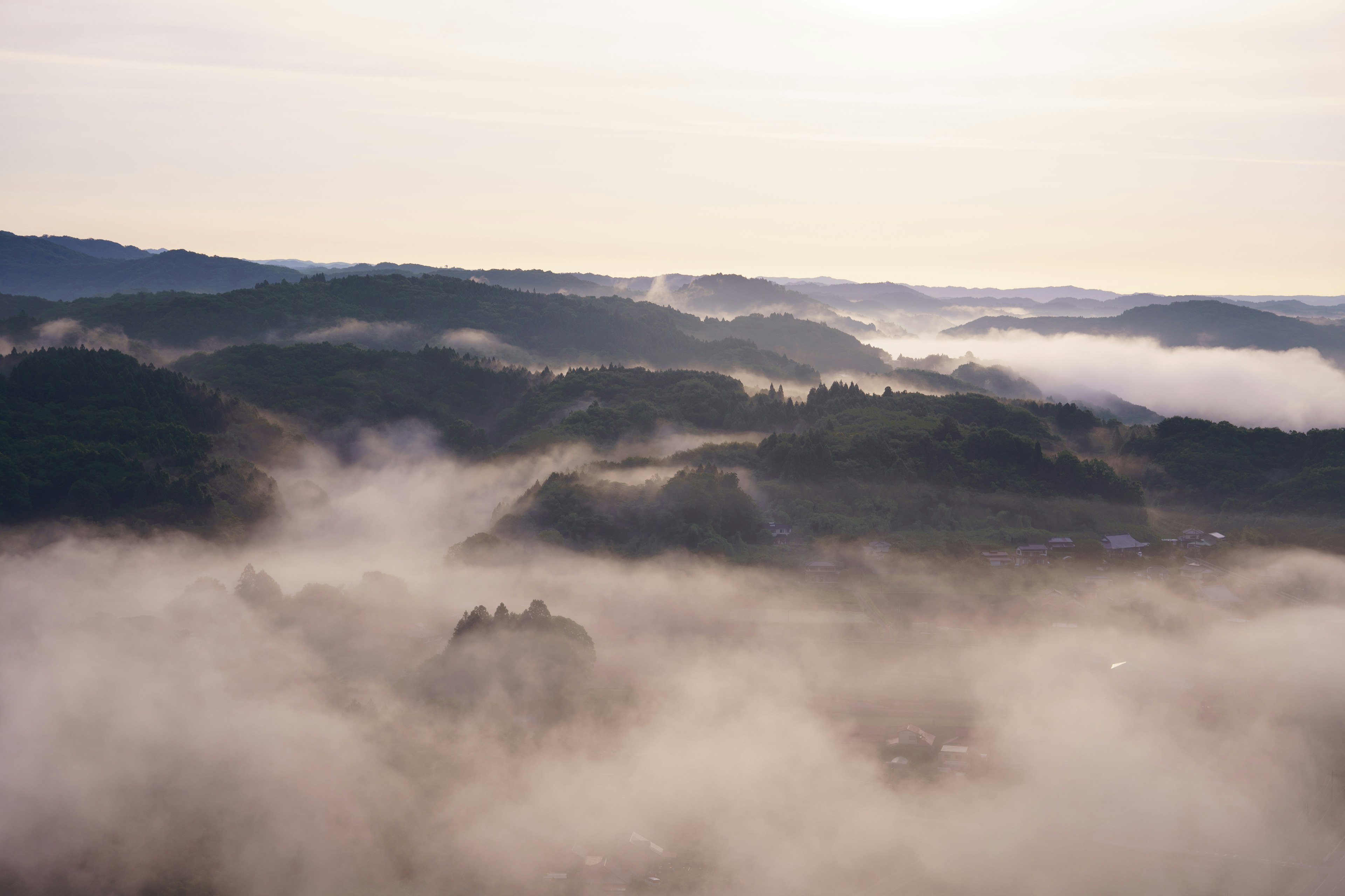 霧に包まれた山々の風景、柔らかな光が差し込む