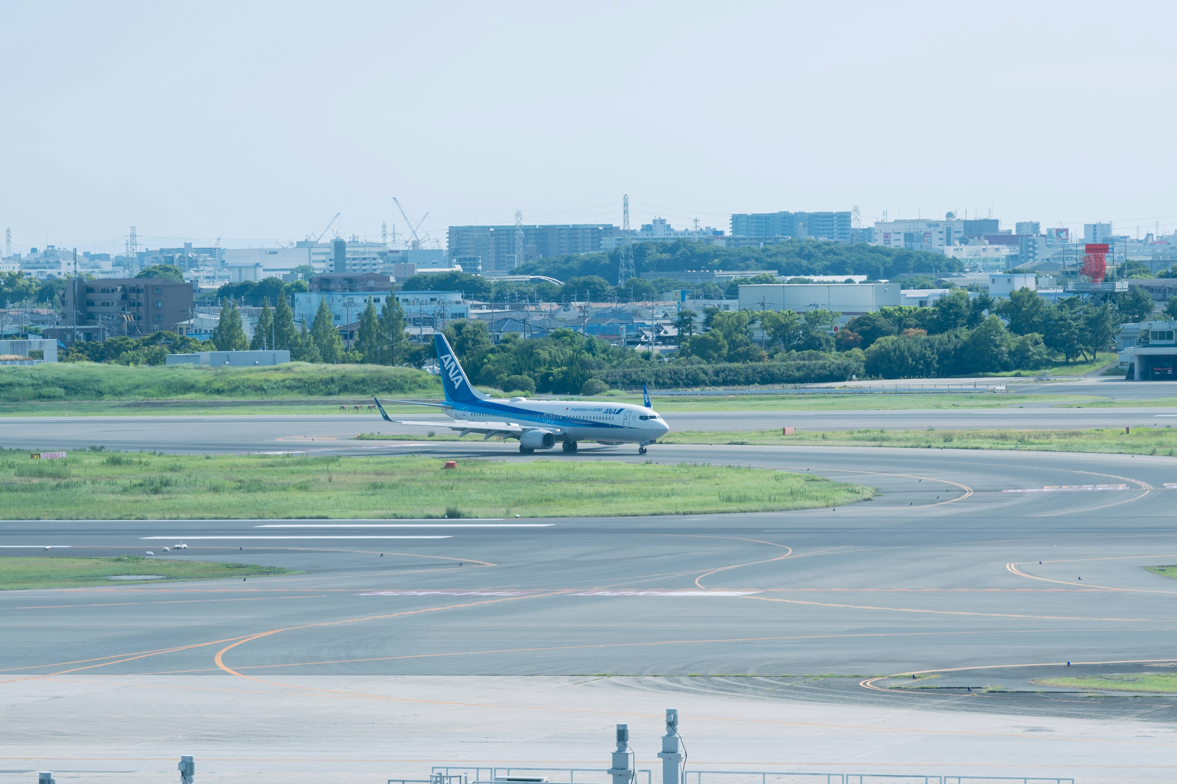 滑走路にいる青い航空機と緑の草地の風景