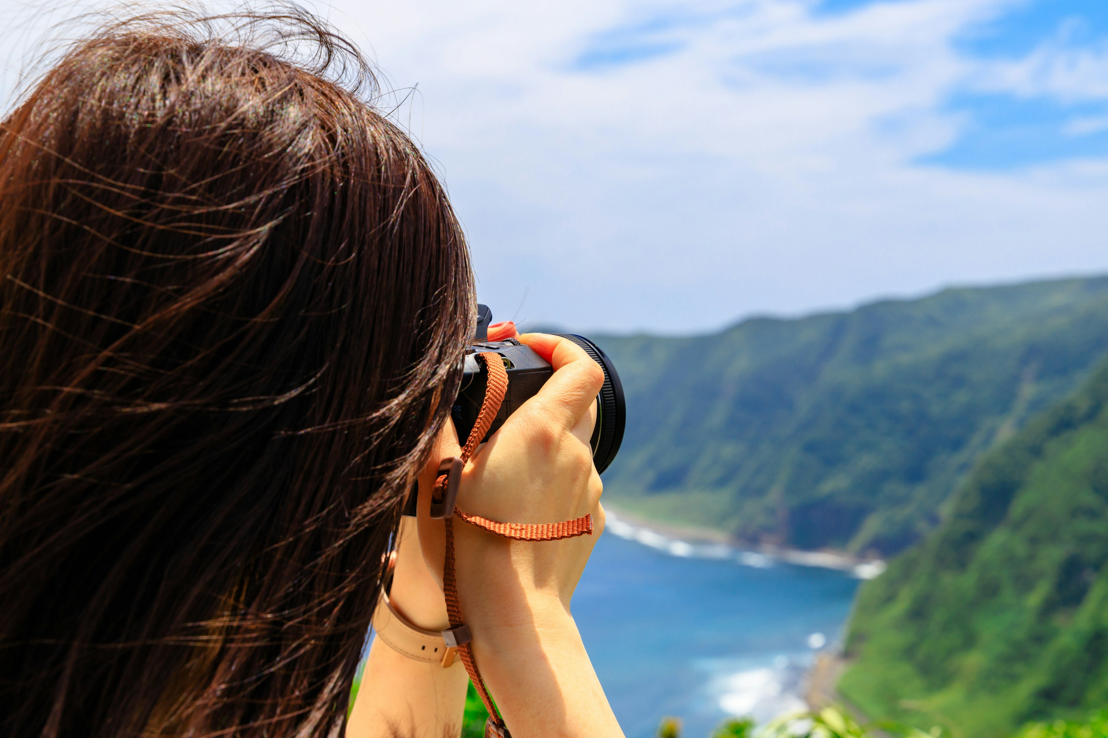 Mujer fotografiando un hermoso paisaje con una cámara