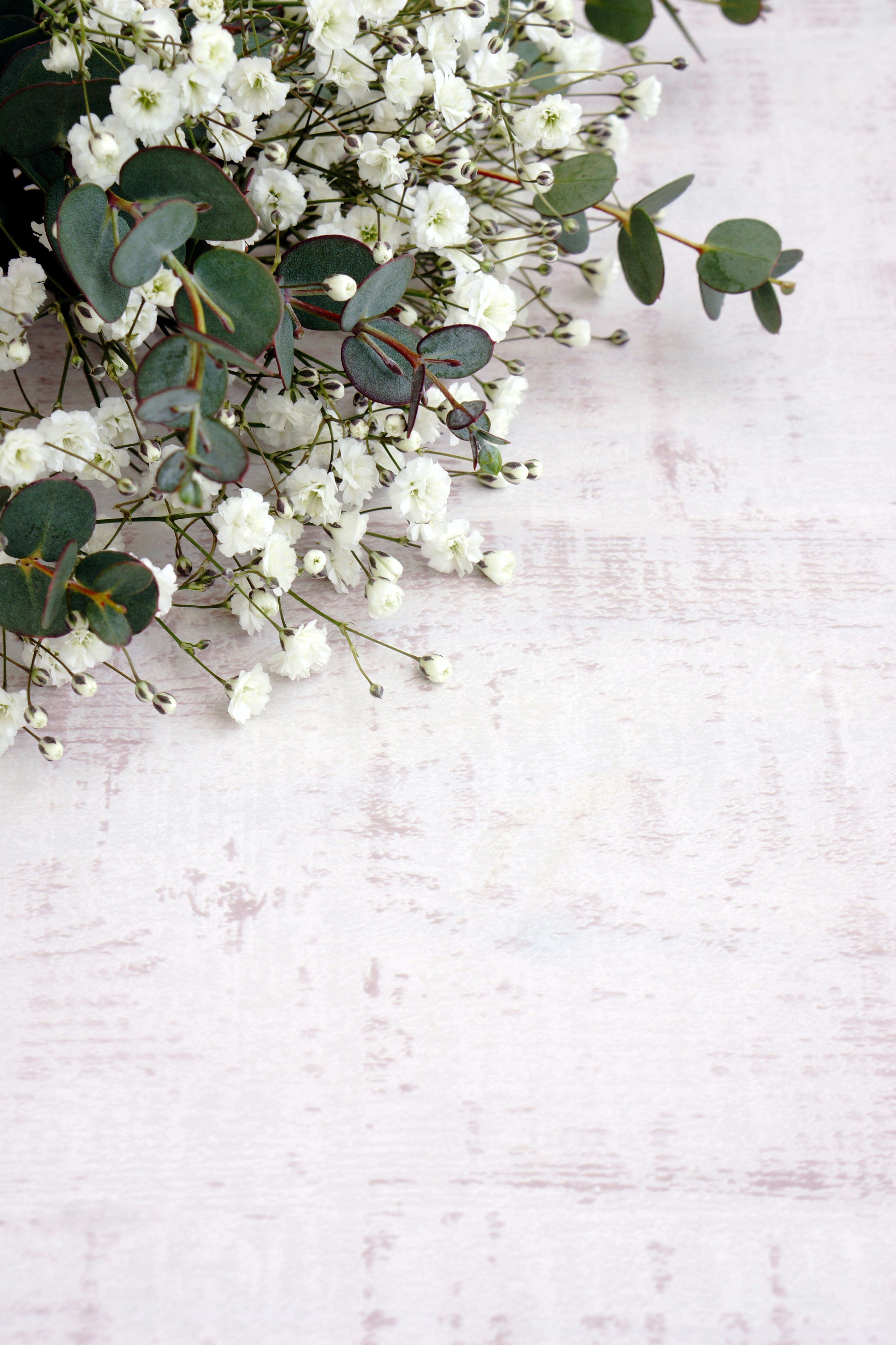 Elegante arreglo floral con flores blancas y hojas de eucalipto