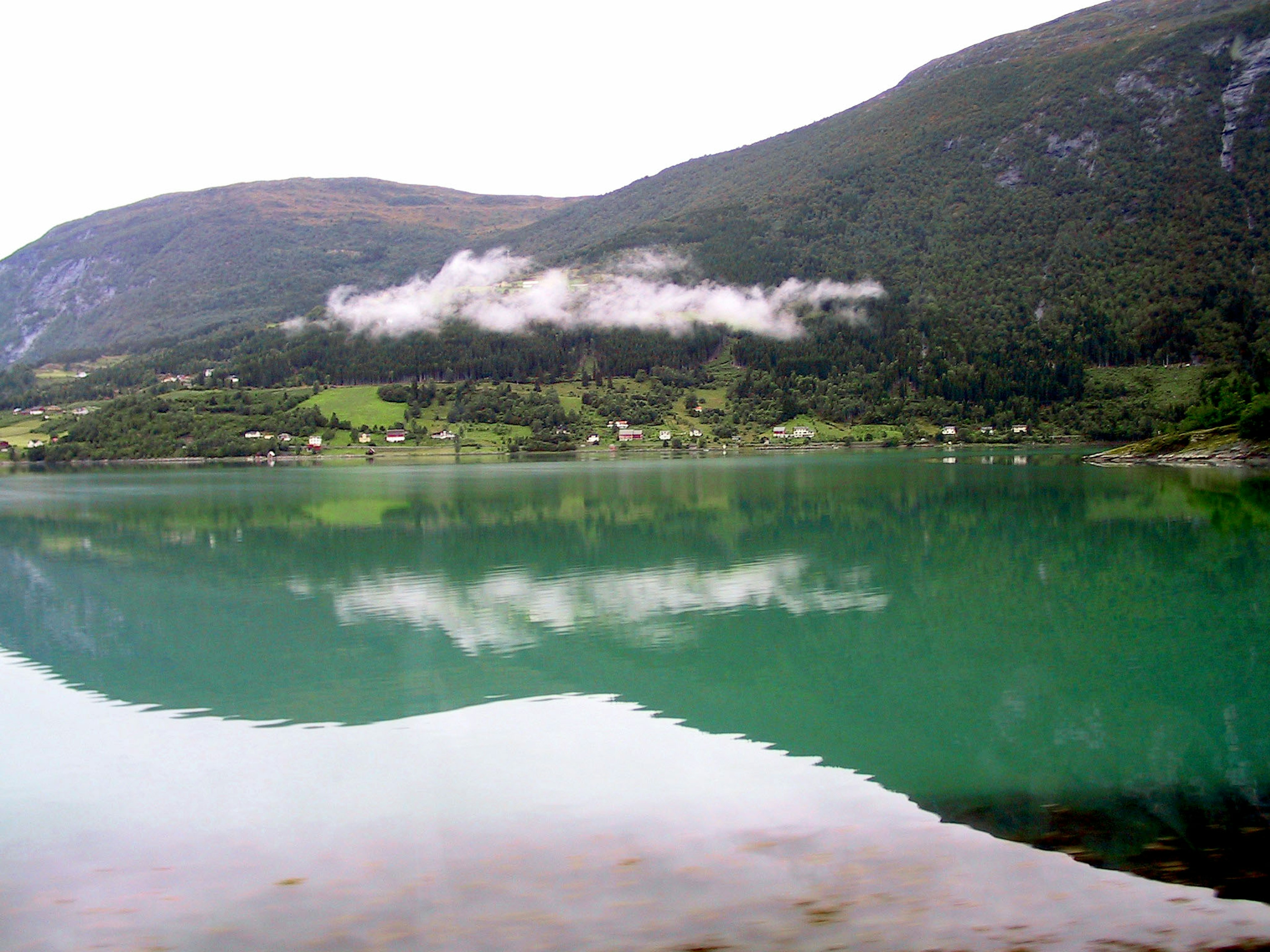 Serene lake reflecting mountains and clouds