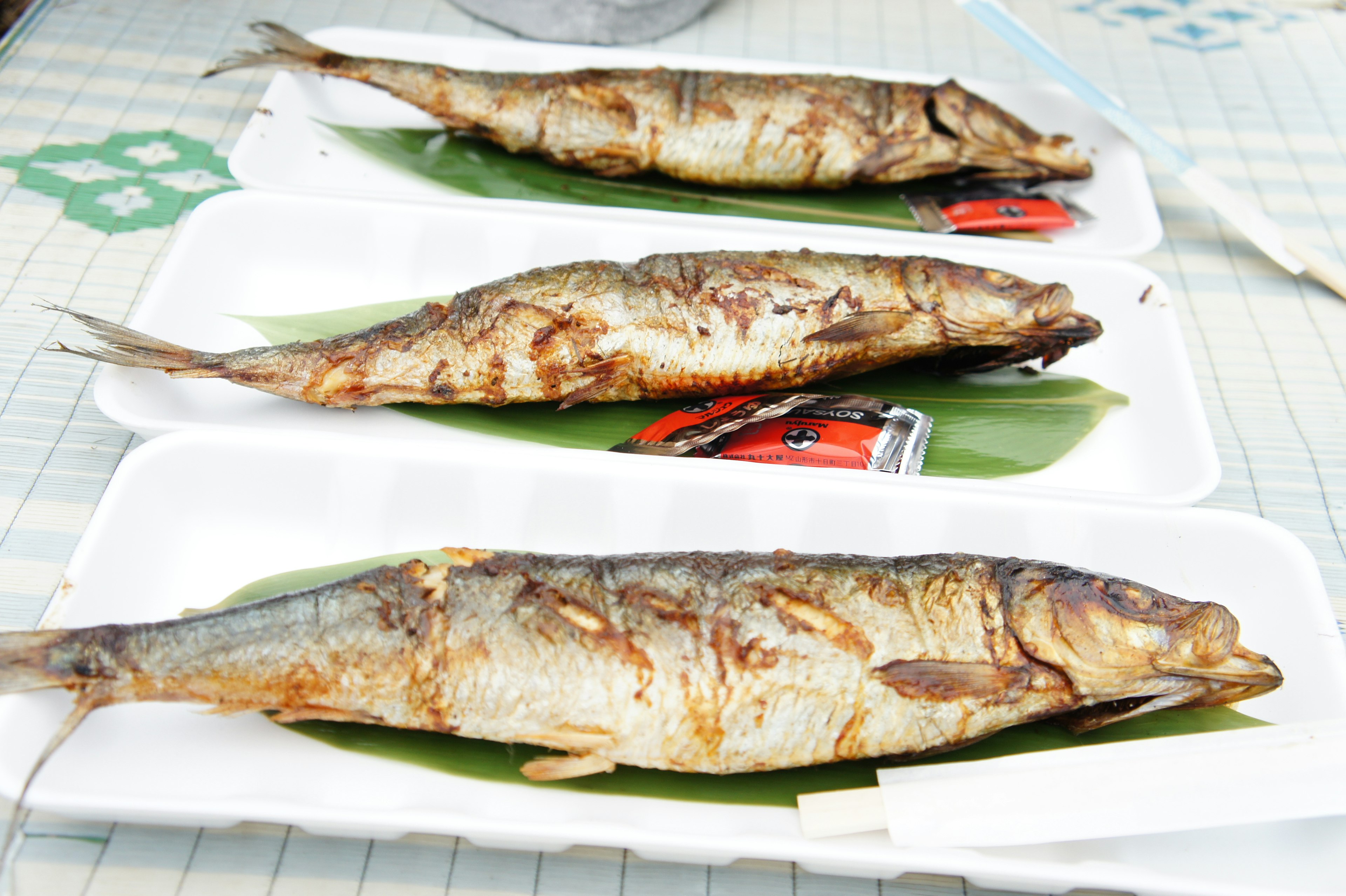 Pescado a la parrilla servido en platos adornados con hojas de plátano