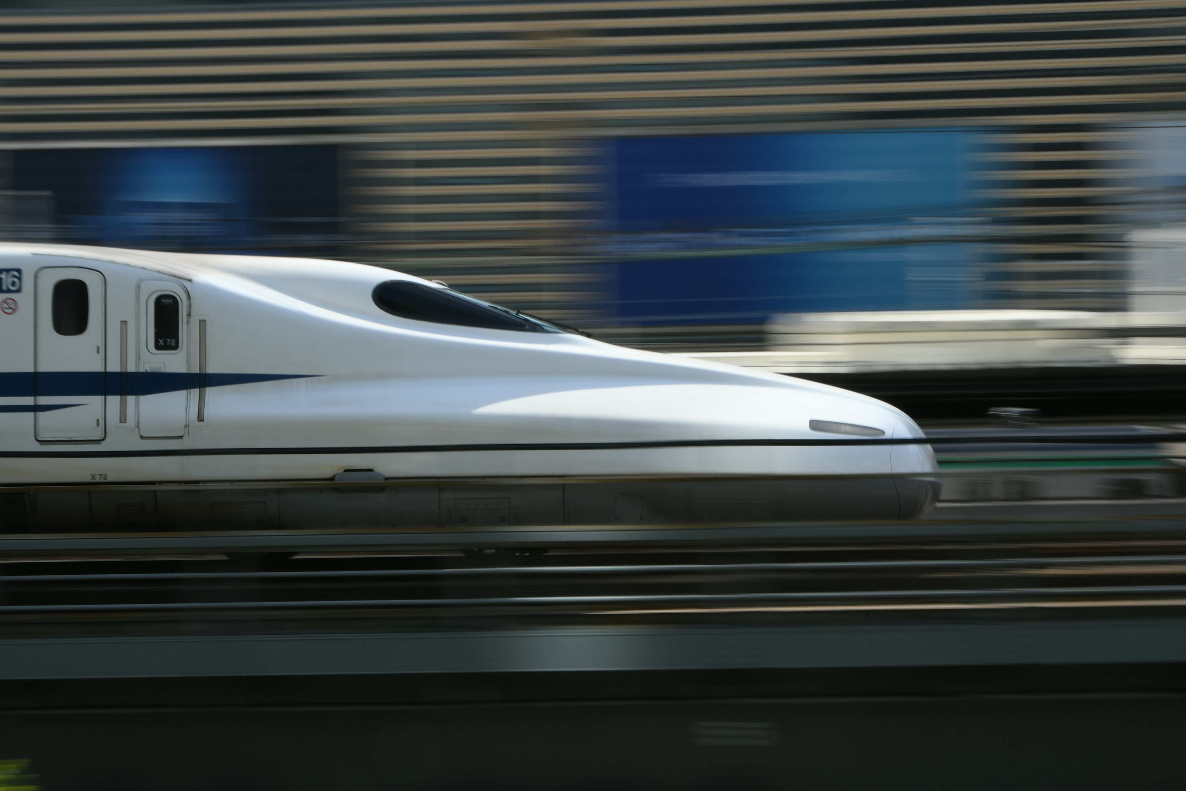 Shinkansen che sfreccia con uno sfondo sfocato