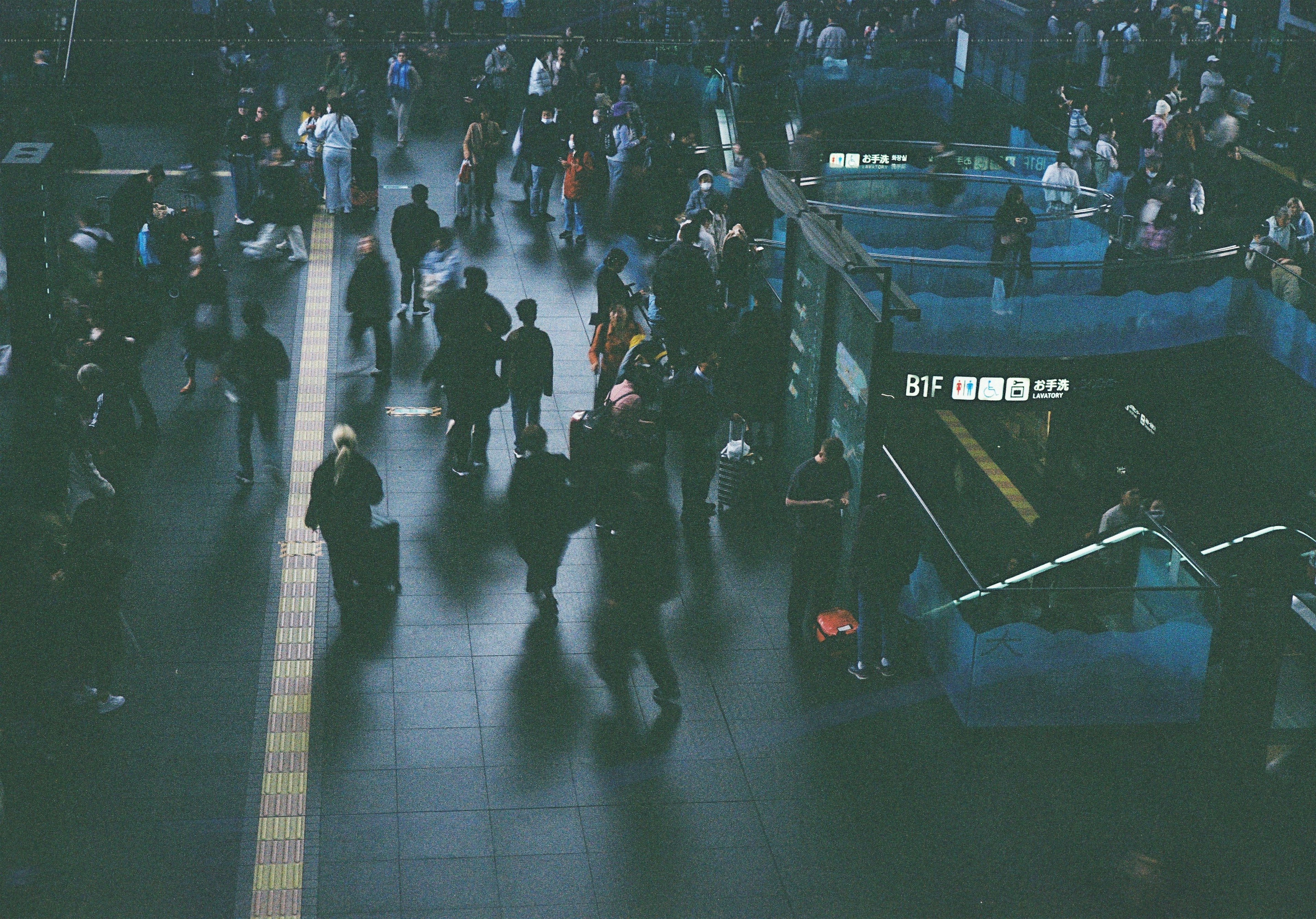 Escena de estación concurrida con gente en movimiento