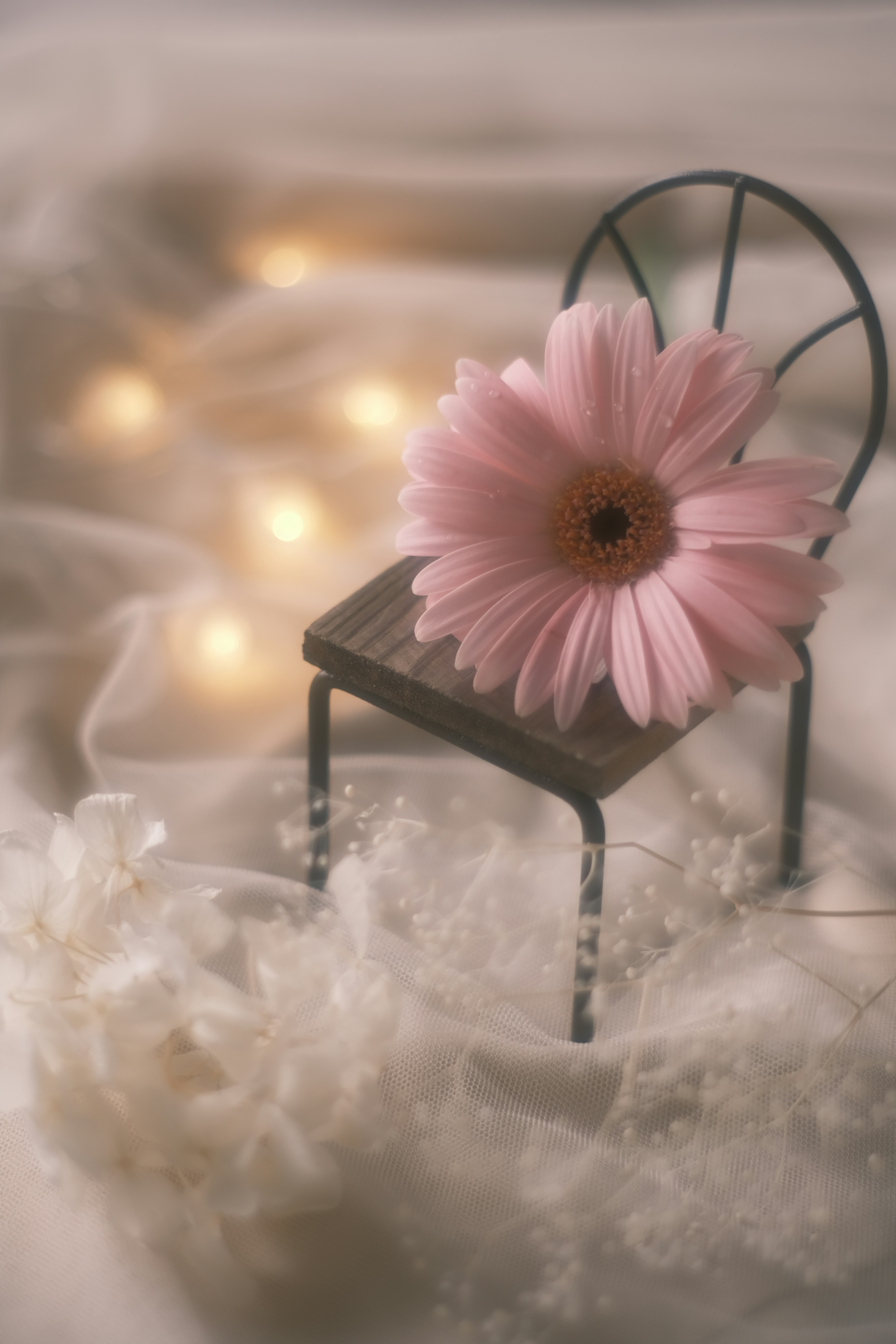 Une petite chaise ornée d'une fleur rose sur un fond doux