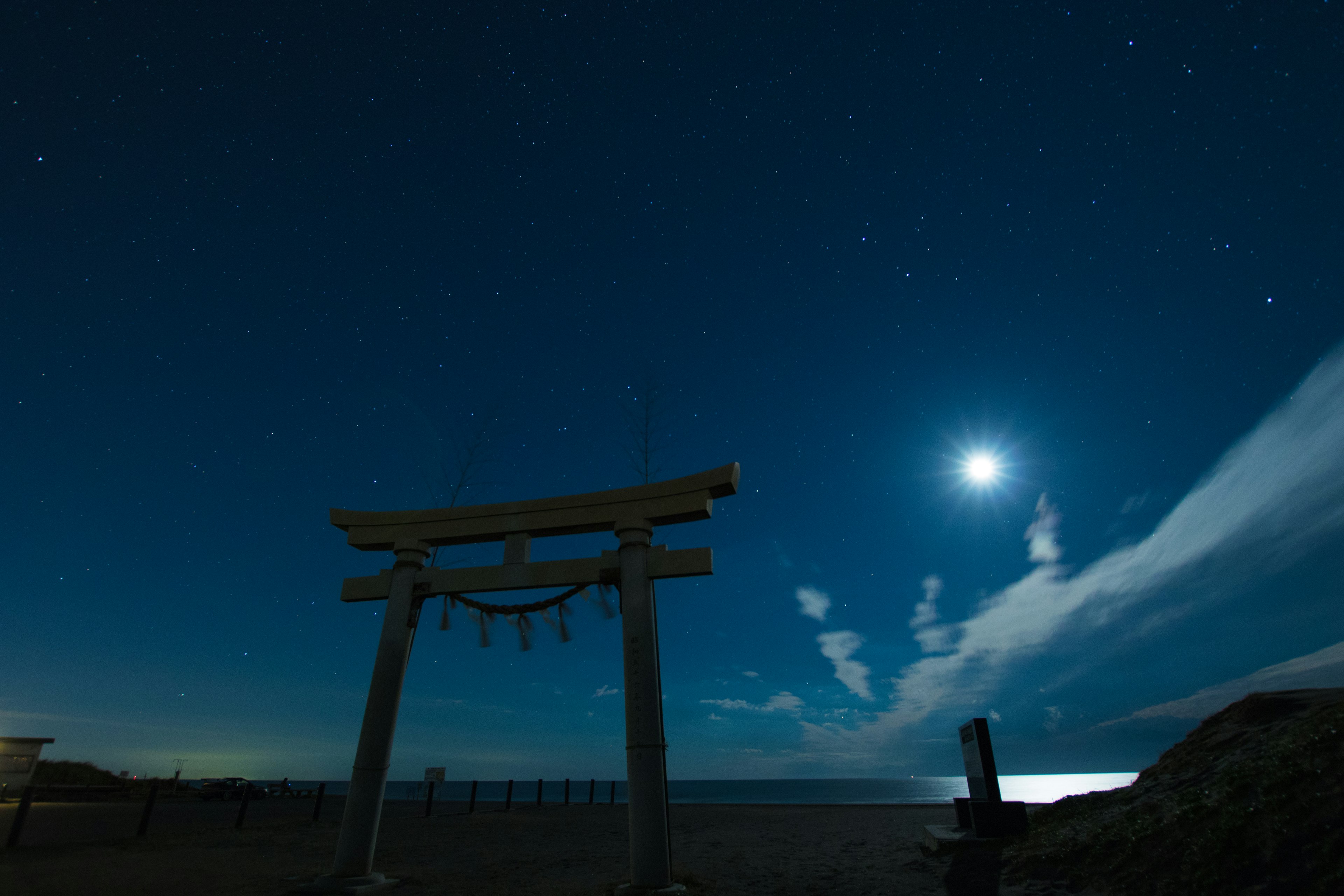 Torii unter einem sternenklaren Nachthimmel mit einem hellen Mond