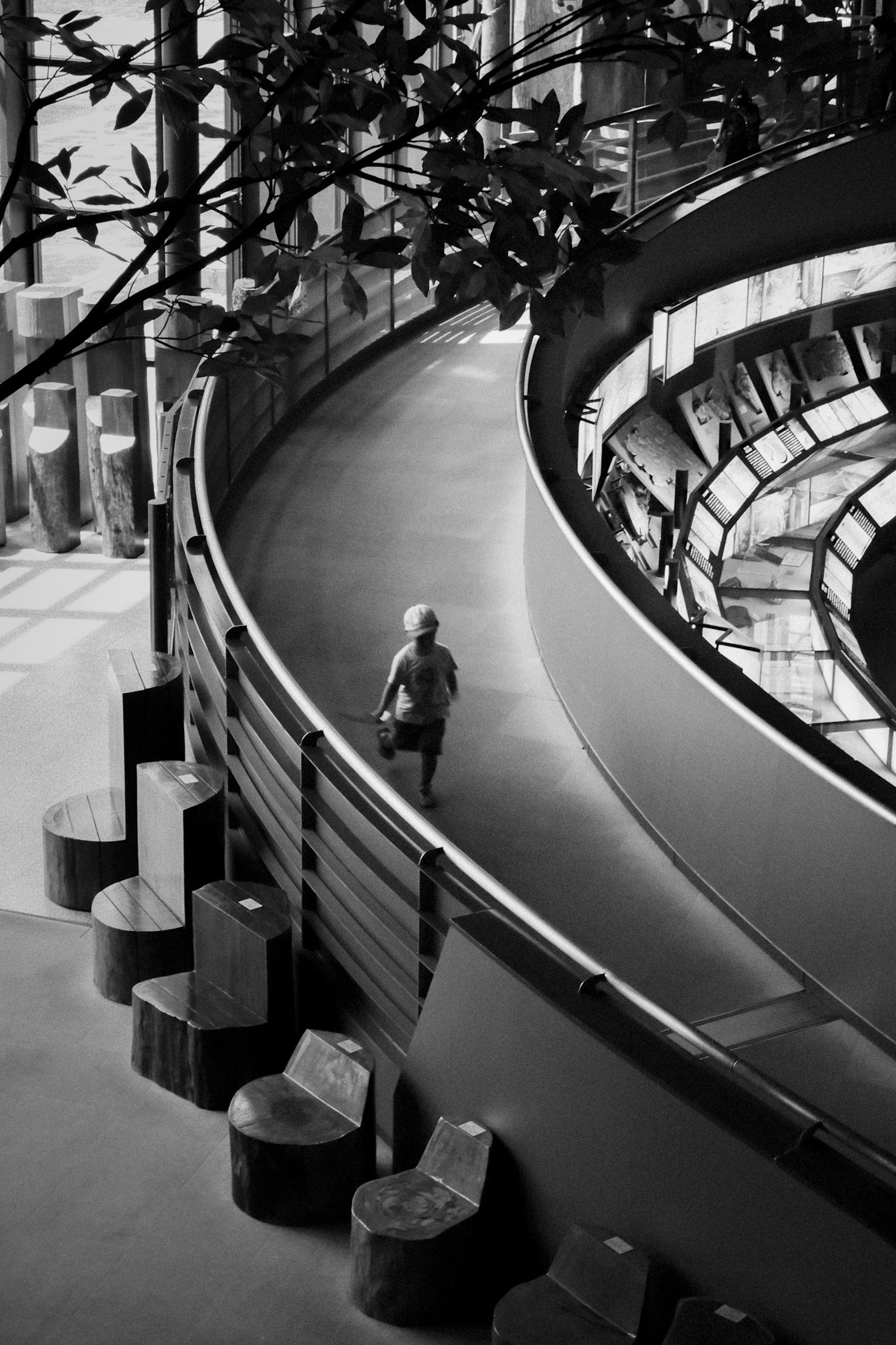 A person walking along a curved corridor with modern architectural elements