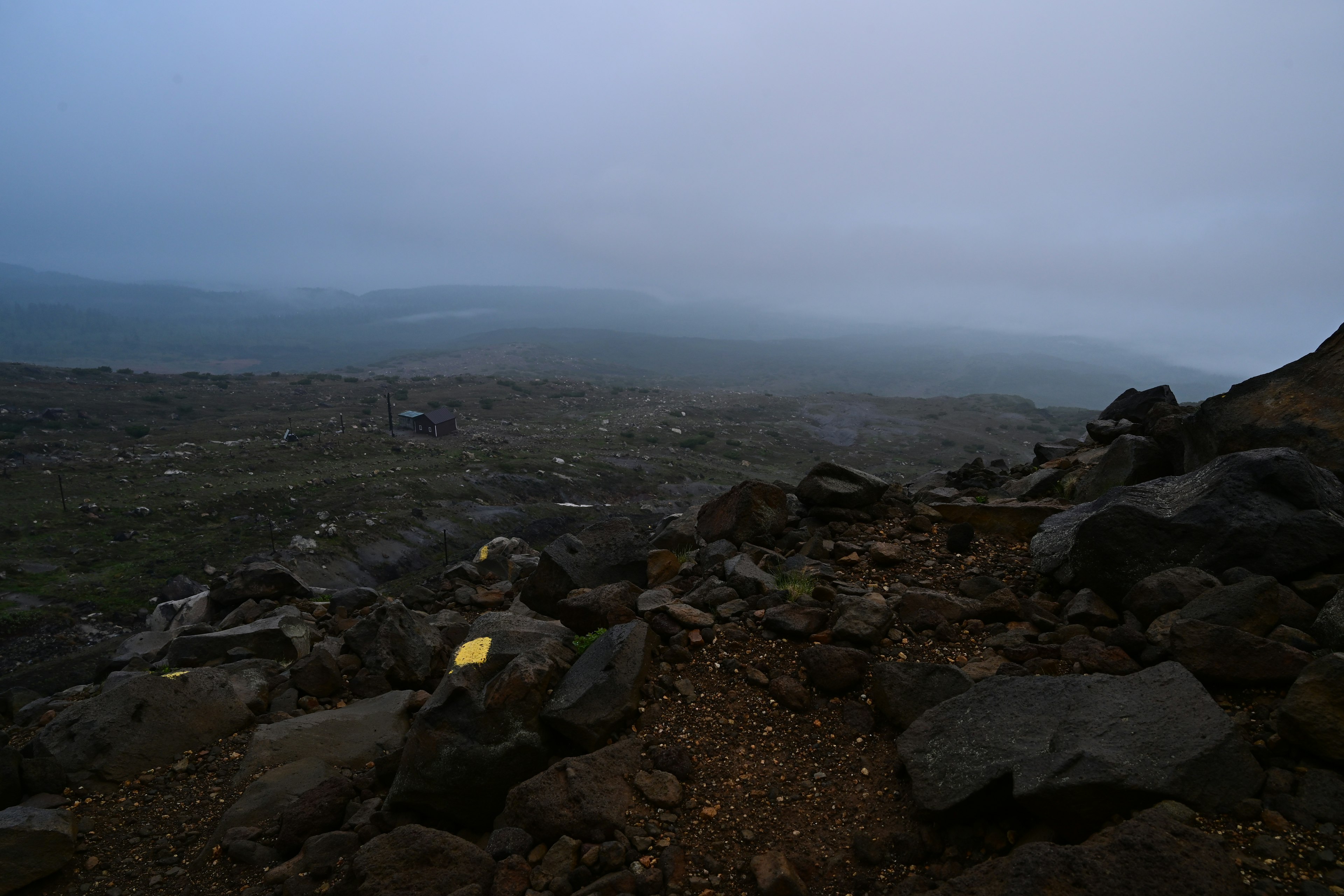 Berglandschaft in Nebel gehüllt mit felsigem Gelände und Wegen