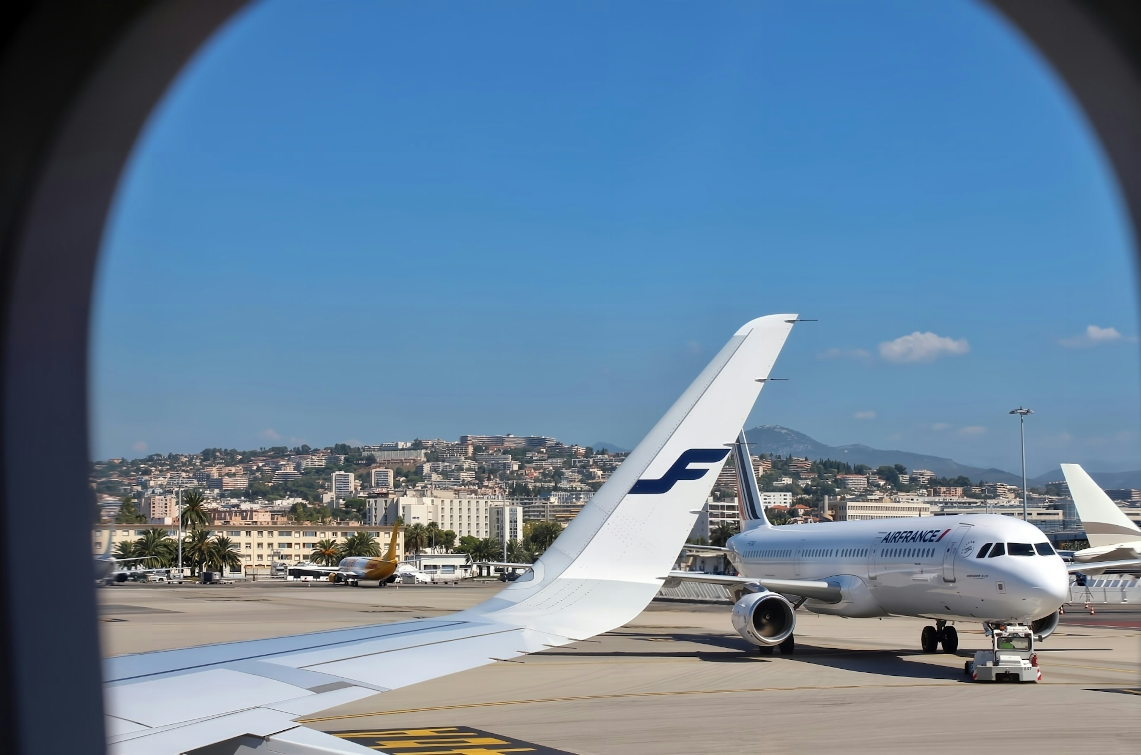 飛行機の窓から見える空港の景色と他の航空機