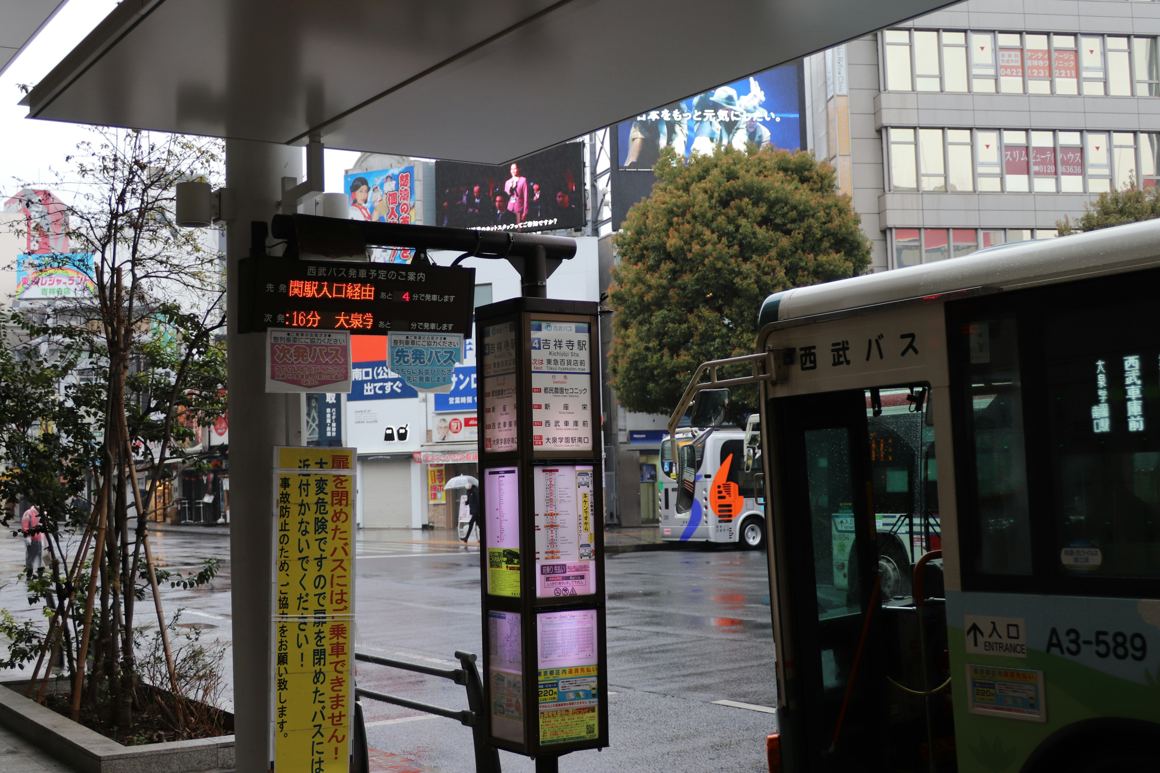 Bus stop with a cityscape in the rain