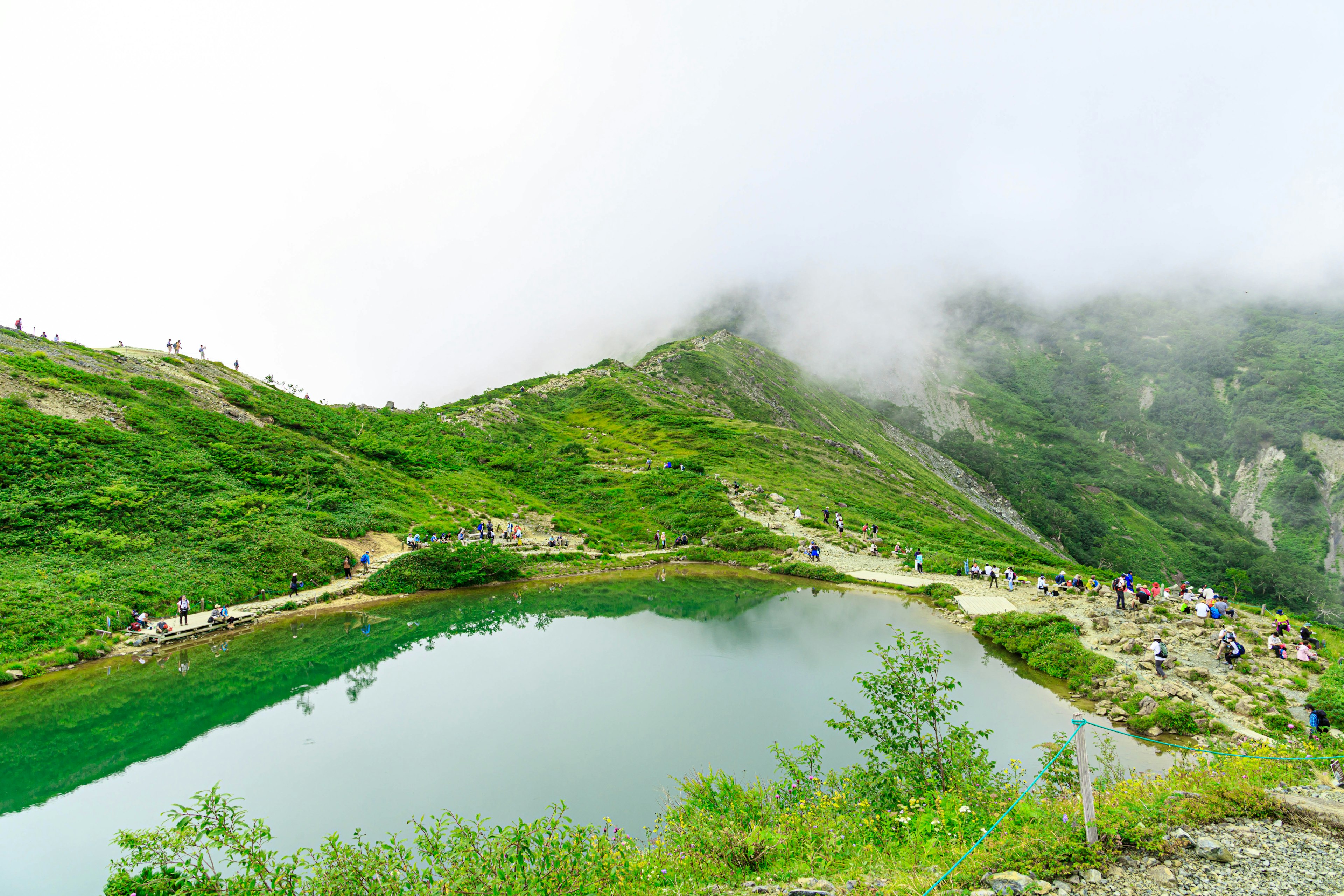 Vista panoramica di un lago tranquillo circondato da montagne verdi