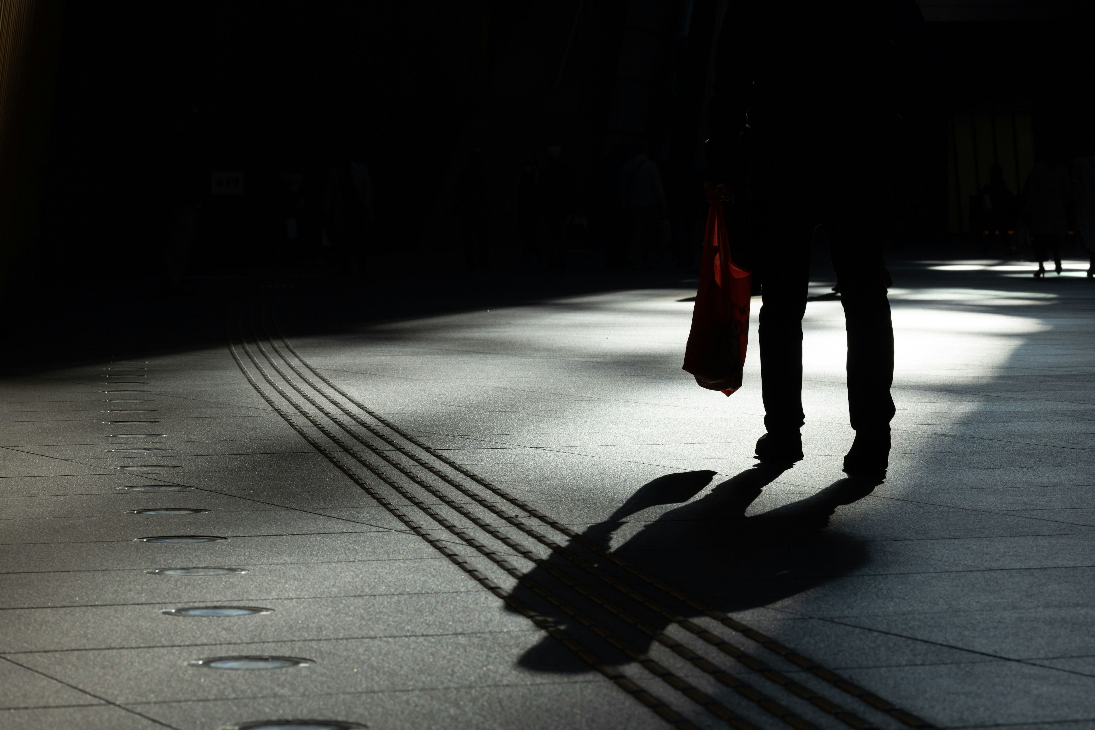 Silhouette d'une personne marchant dans l'ombre avec des lignes au sol