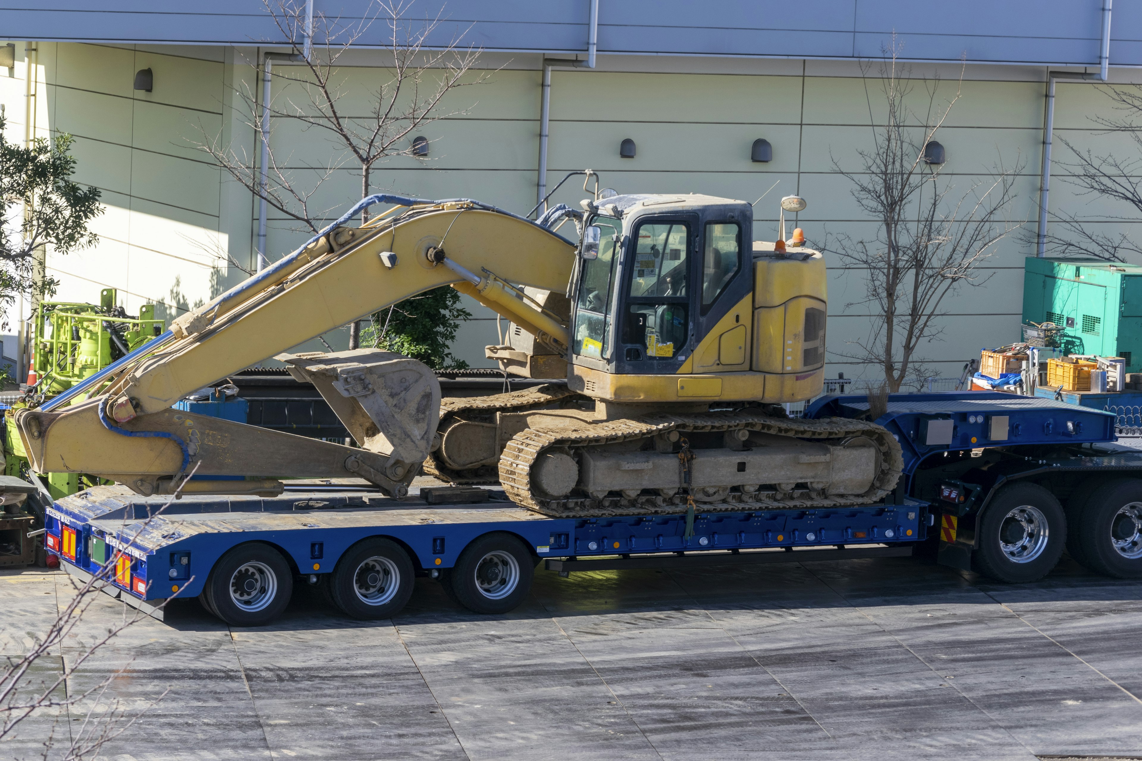 Excavatrice chargée sur une remorque bleue